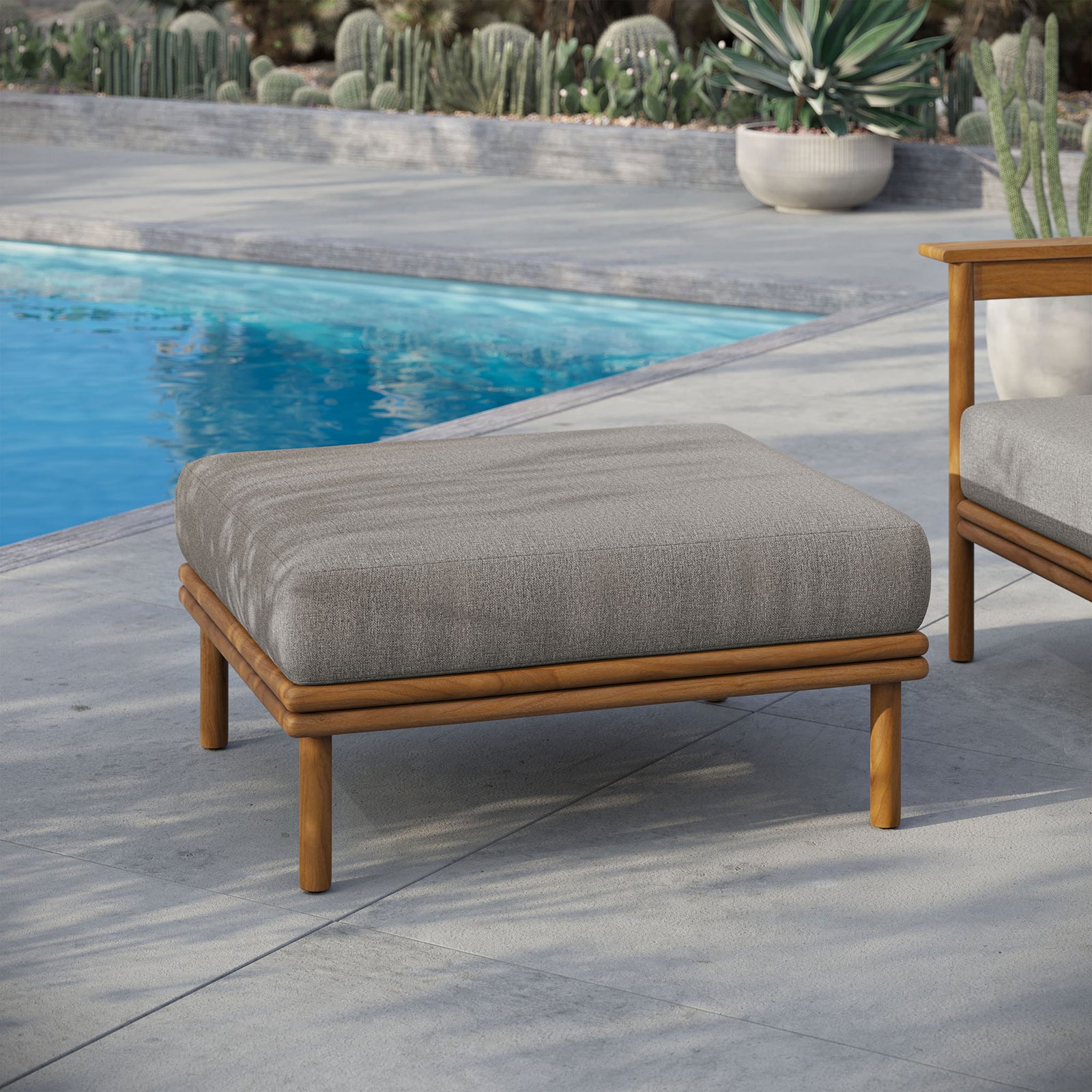 Poolside teak ottoman with neutral cushion brings resort-style comfort to modern outdoor seating. || EEI-7009-NAT-DRI || front_angle_room