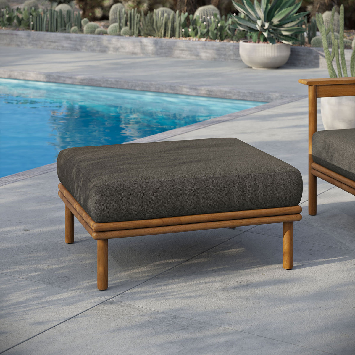 Charcoal-toned cushion and teak frame anchor a chic poolside lounge with resort-inspired ease. || EEI-7009-NAT-FLI || front_angle_room