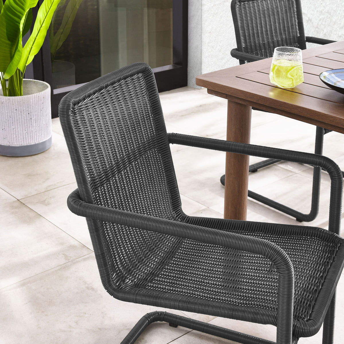 Slate wicker patio chair at the table adding crisp contrast to a light outdoor setting || EEI-7014-SLA || detail_room