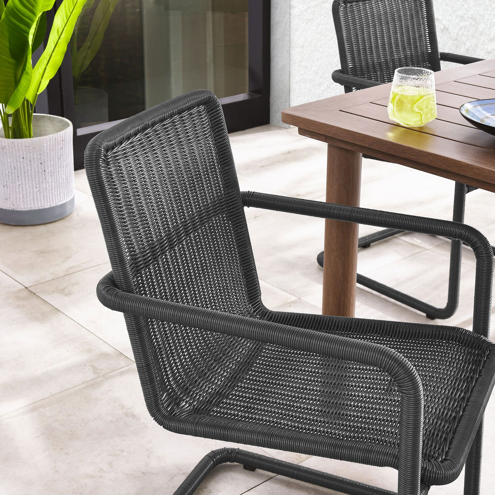 Slate wicker patio chair at the table adding crisp contrast to a light outdoor setting || EEI-7014-SLA || detail_room