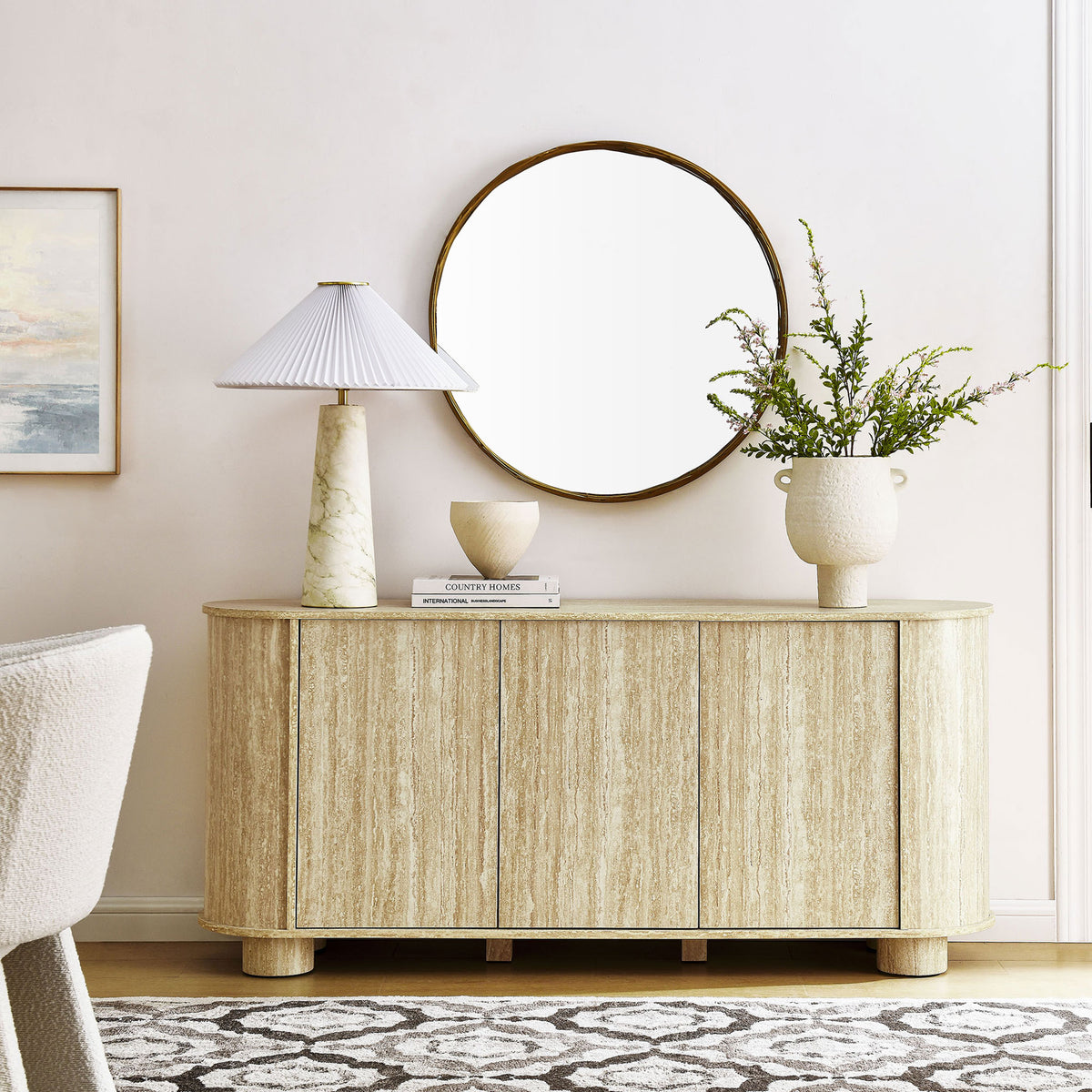 Sideboard in travertine finish anchors a bright living space with ample concealed storage and rounded form. || EEI-7015-TRA || front_room