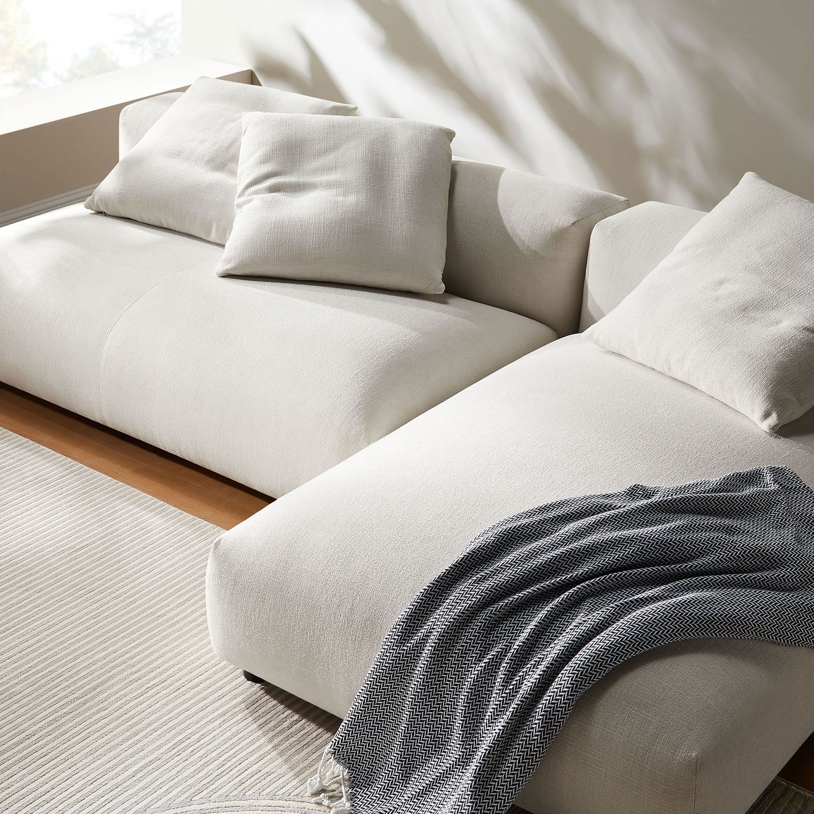 Cozy close-up of the salt fabric sectional with accent pillows and soft throw blanket || EEI-7025-SAL || detail_room
