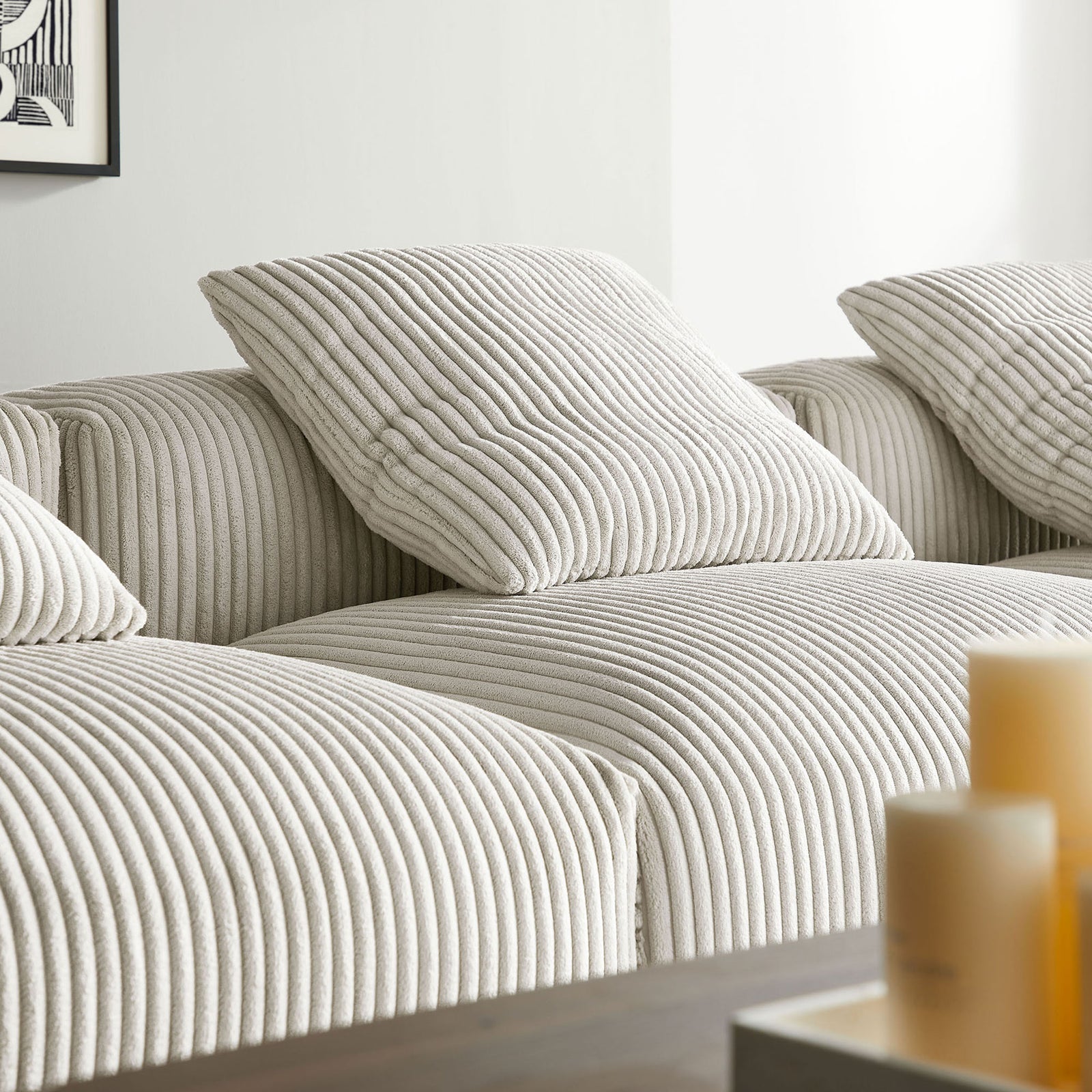 Close up of plush corduroy cushions and accent pillows showcasing the Solace sectional texture || EEI-7026-ALM || detail_room
