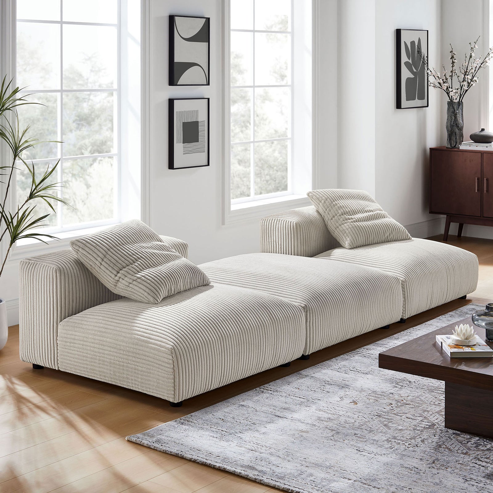 Modern living room scene featuring the Solace almond corduroy modular sectional and accent pillows || EEI-7028-ALM || front_angle_room