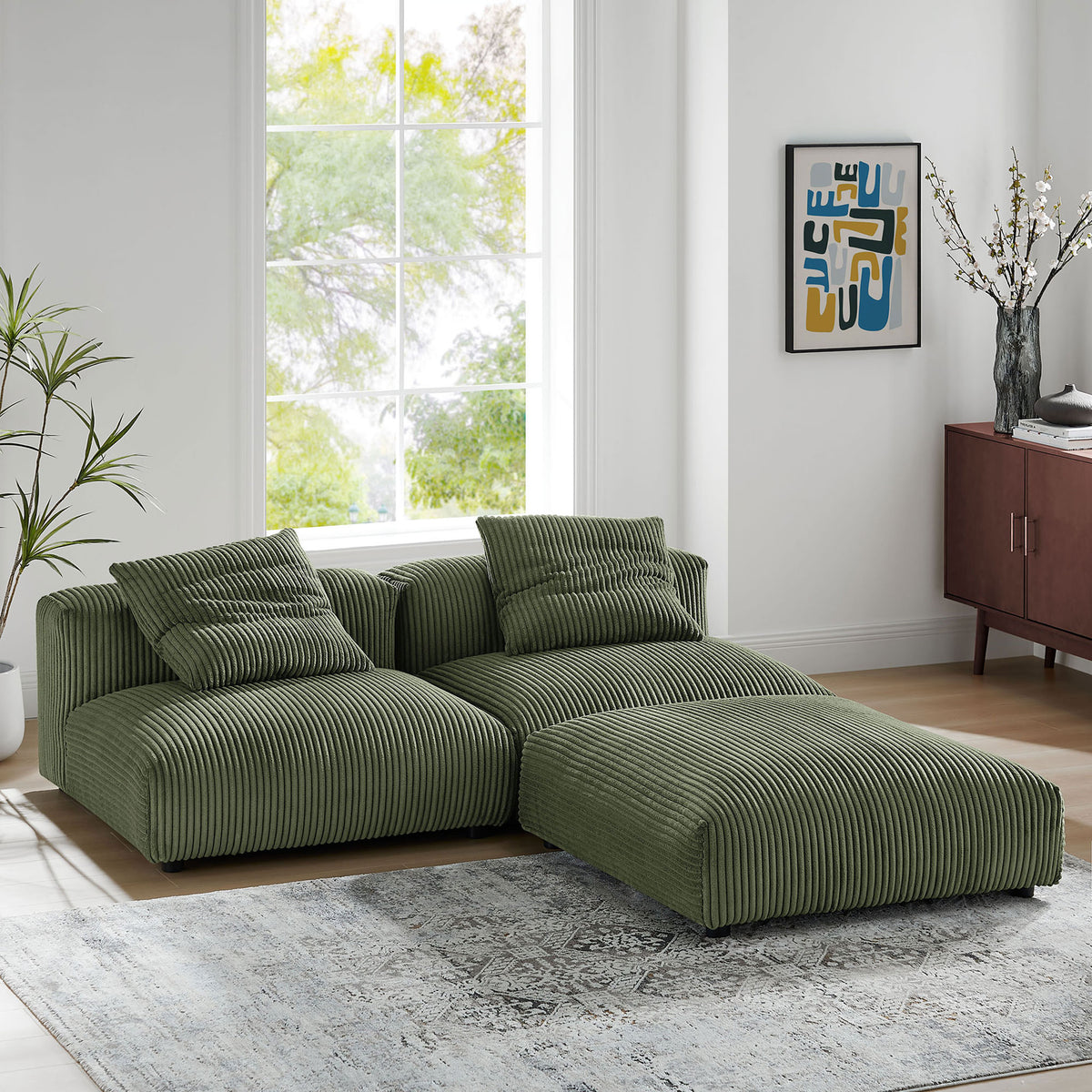 Fern corduroy sectional in an L-shaped layout, shown in a sunlit living room with artful accents and soft textures. || EEI-7028-FRN || front_angle_room