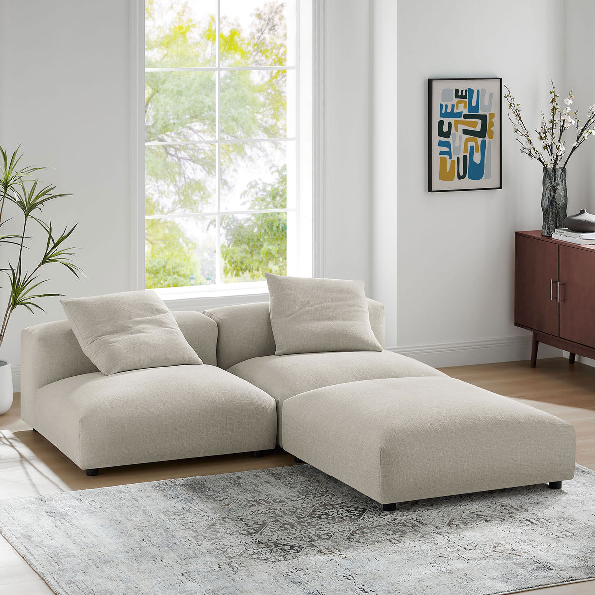 L shaped linen modular sectional forming a chaise lounge in a modern sunlit living room || EEI-7029-LIN || front_angle_room