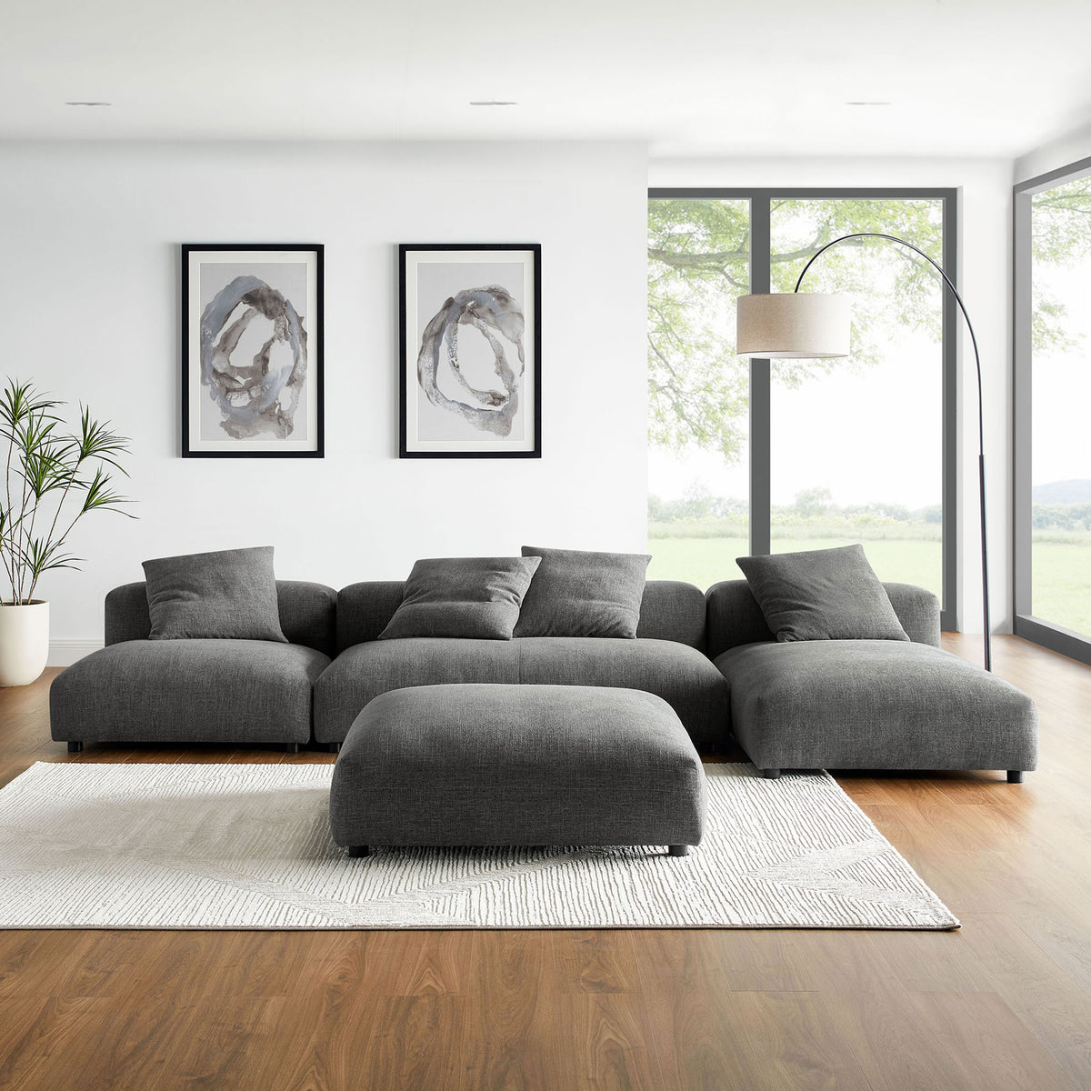 Charcoal Solace modular sectional with ottoman anchored on a light rug in a bright contemporary living room || EEI-7033-CHA || front_room