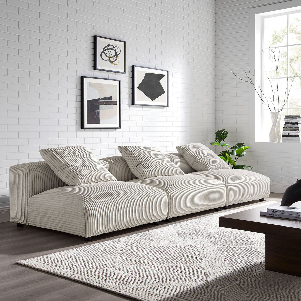 Almond corduroy modular sofa anchors a bright modern living room with low-profile seating and layered texture || EEI-7034-ALM || front_angle_room