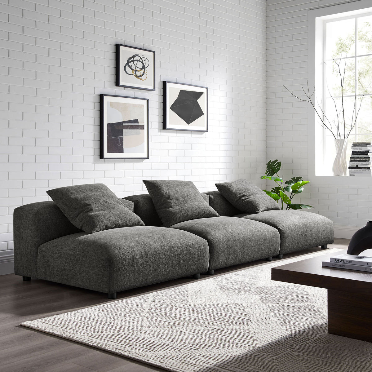 Charcoal modular sofa arranged in a bright living room with a textured rug and modern wall art || EEI-7035-CHA || front_angle_room