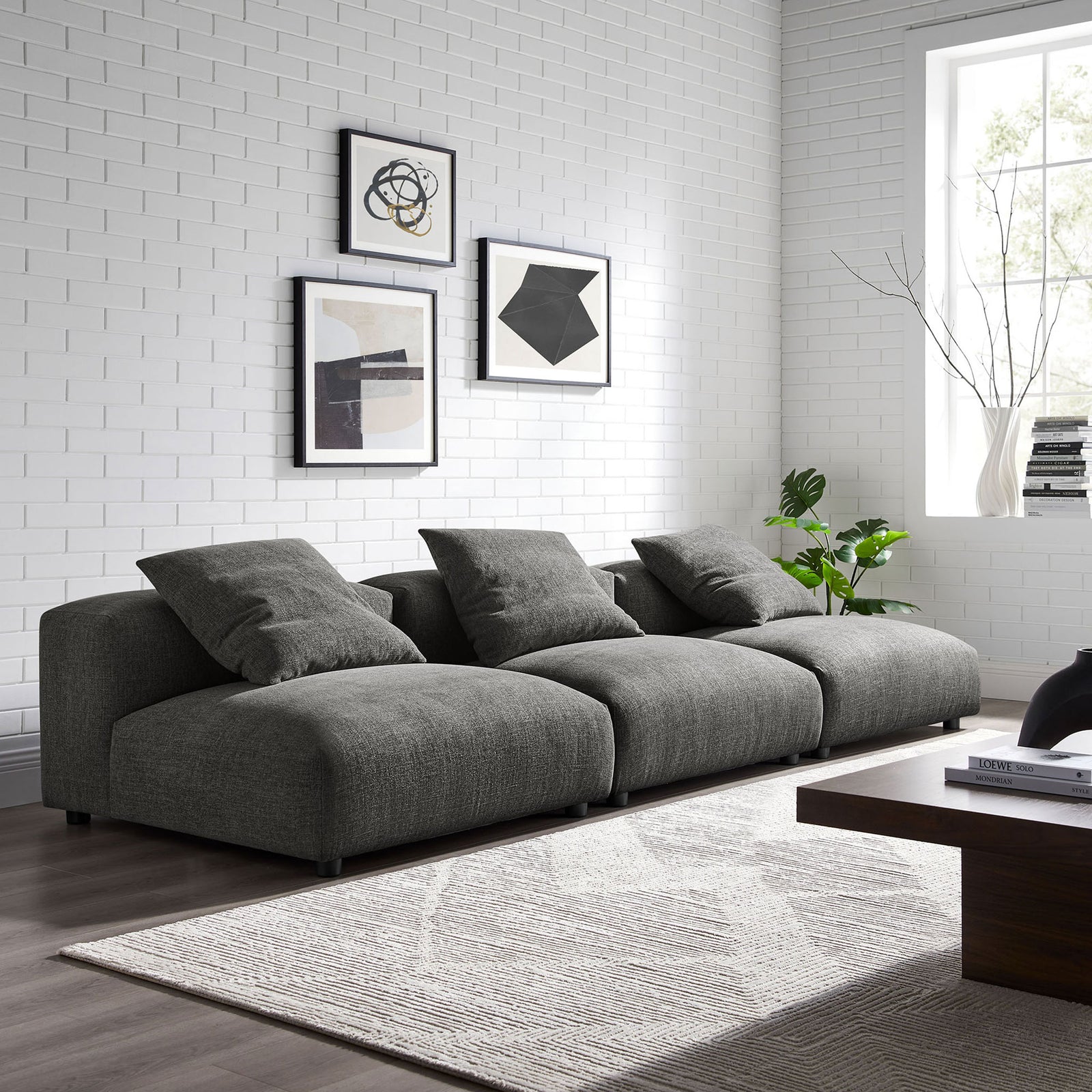 Charcoal modular sofa arranged in a bright living room with a textured rug and modern wall art || EEI-7035-CHA || front_angle_room