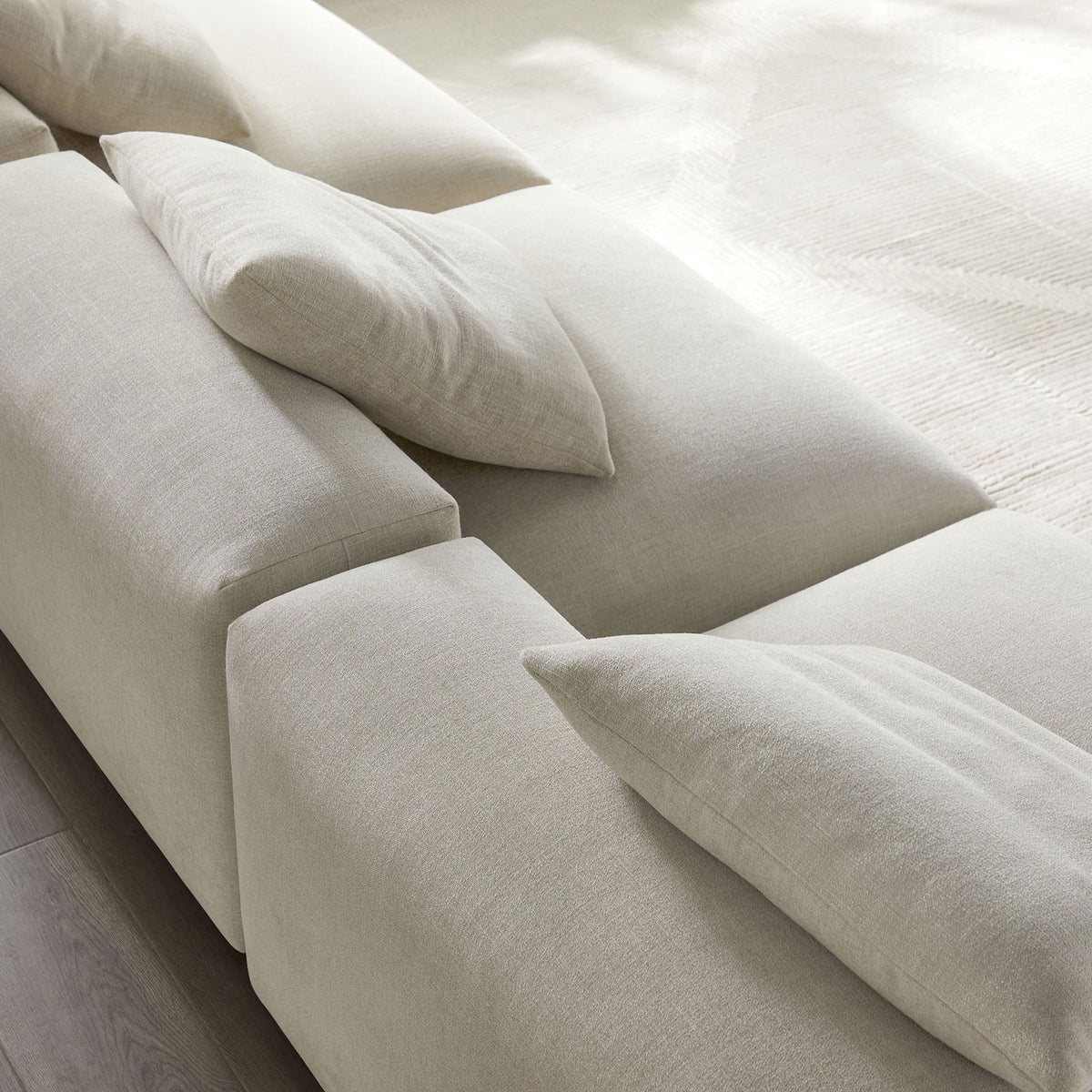 Close-up of soft textured linen upholstery and plush pillows on modular sofa seats || EEI-7035-LIN || detail_room