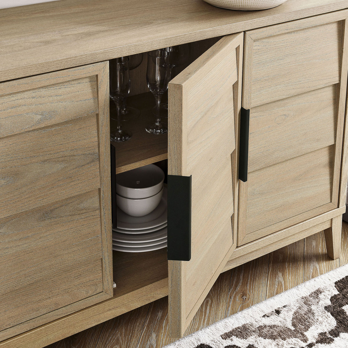 Sinya sideboard doors partially open to show organized glassware and dinnerware on the interior shelves. || EEI-7040-LOA || storage_open_room