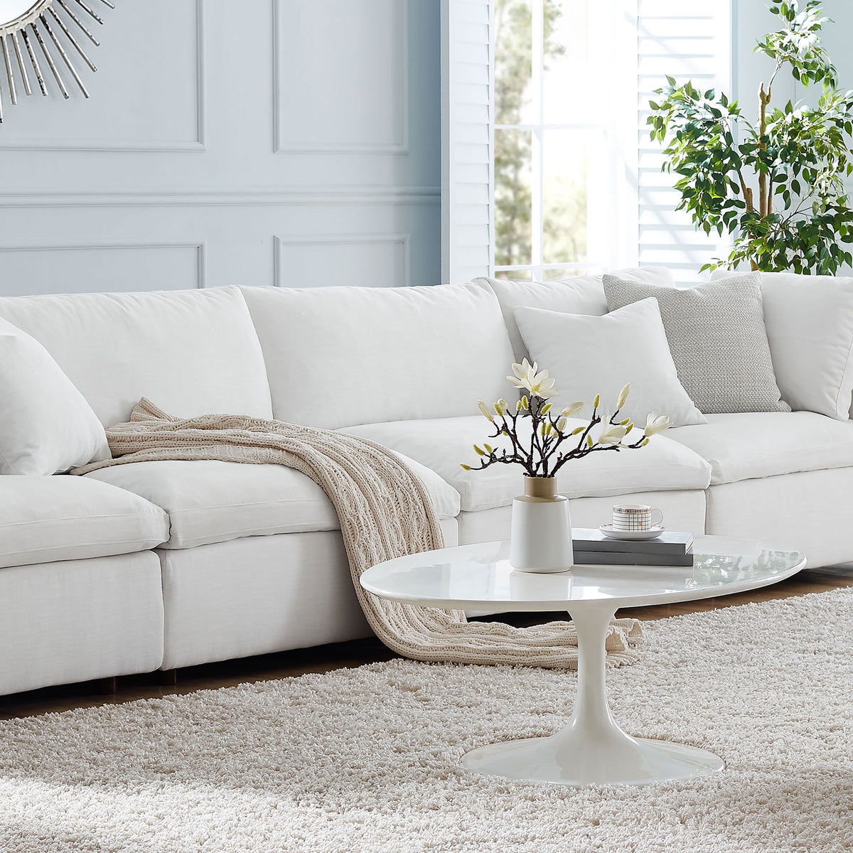 White overstuffed modular sofa styled in a bright living room with cozy throw blanket and accent pillow || EEI-7043-WHI || front_angle_multi_room
