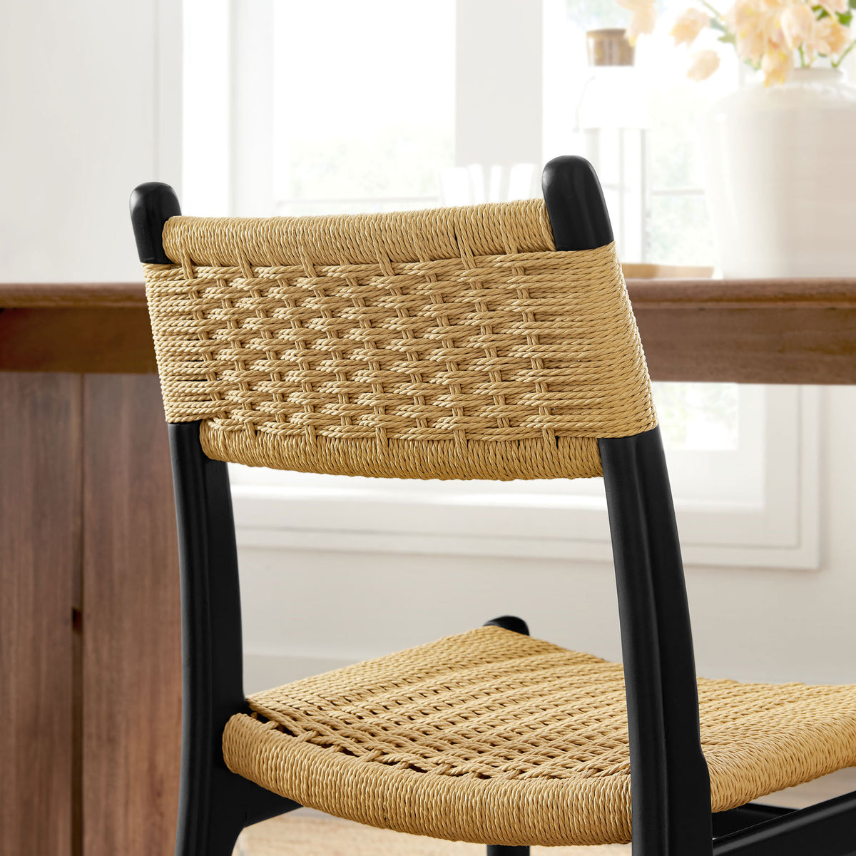 Natural rope backrest of black wood dining chair styled in a bright dining room || EEI-7044-BLK-NAT || detail_room