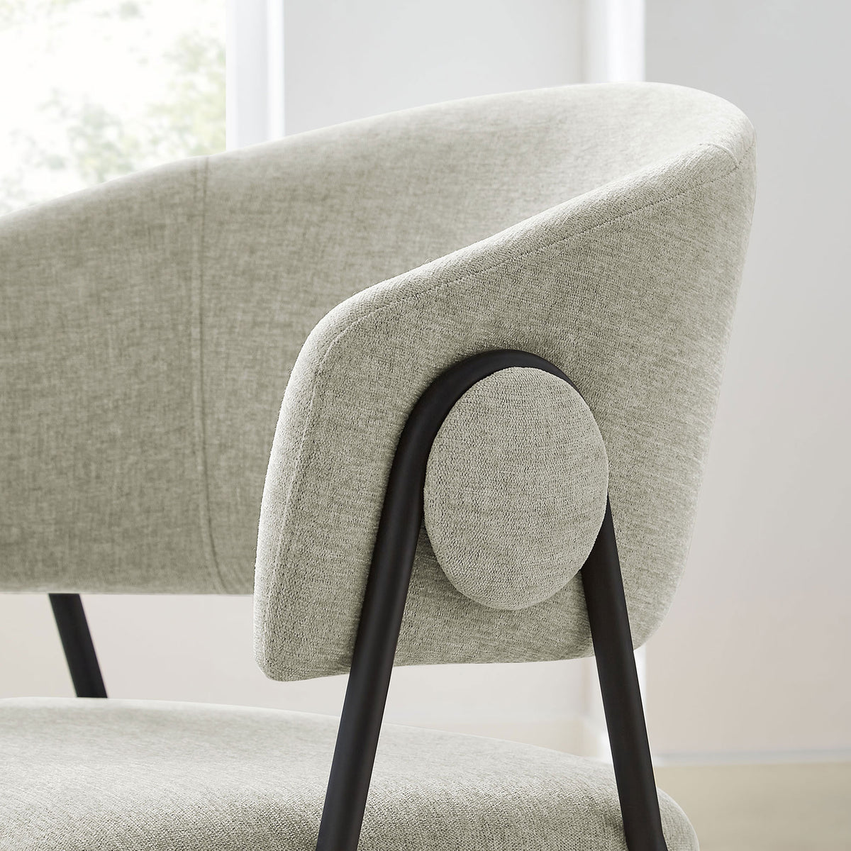 Rounded arm and side button design of the taupe chenille dining chair in a bright dining room. || EEI-7045-TAU-BLK || detail_room