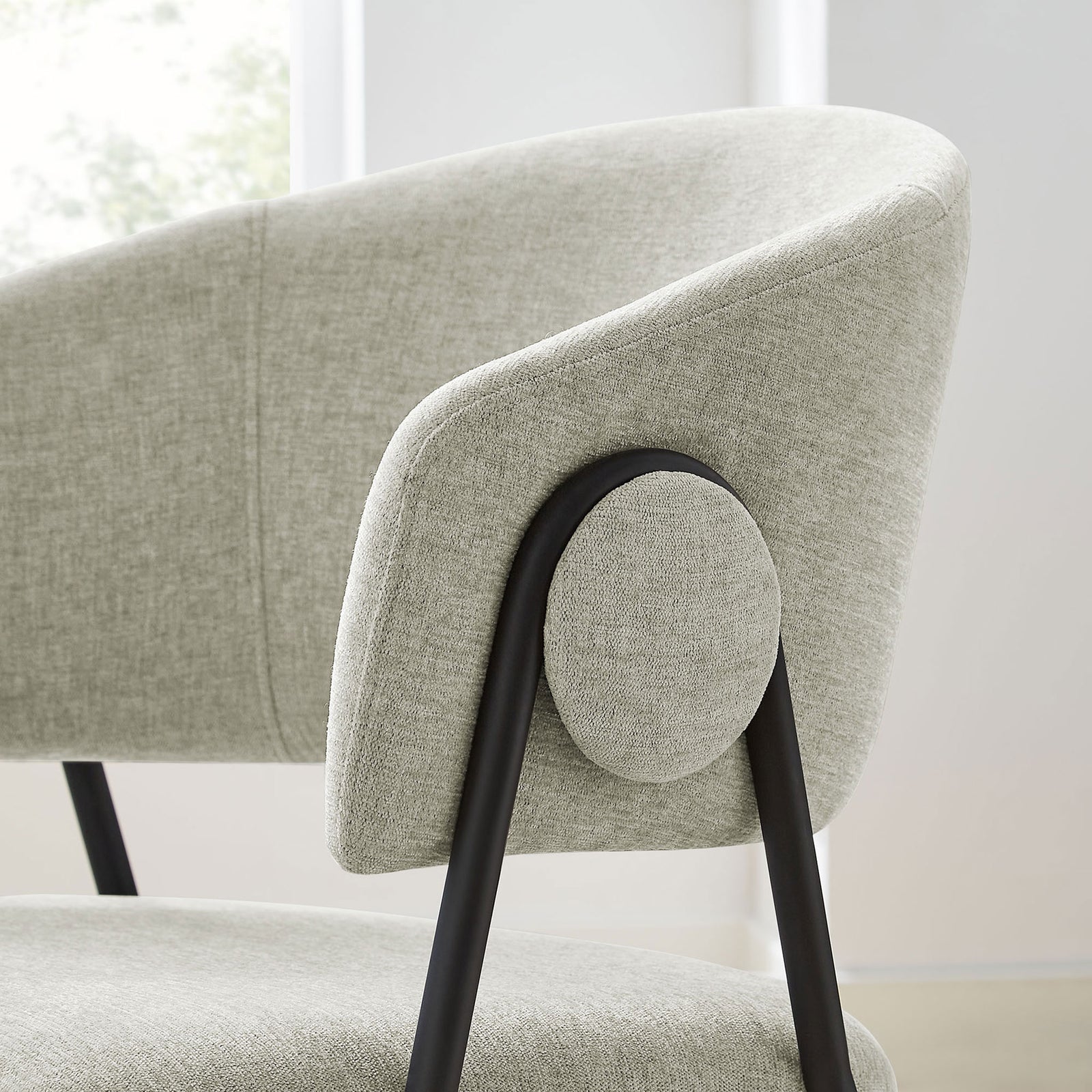 Rounded arm and side button design of the taupe chenille dining chair in a bright dining room. || EEI-7045-TAU-BLK || detail_room