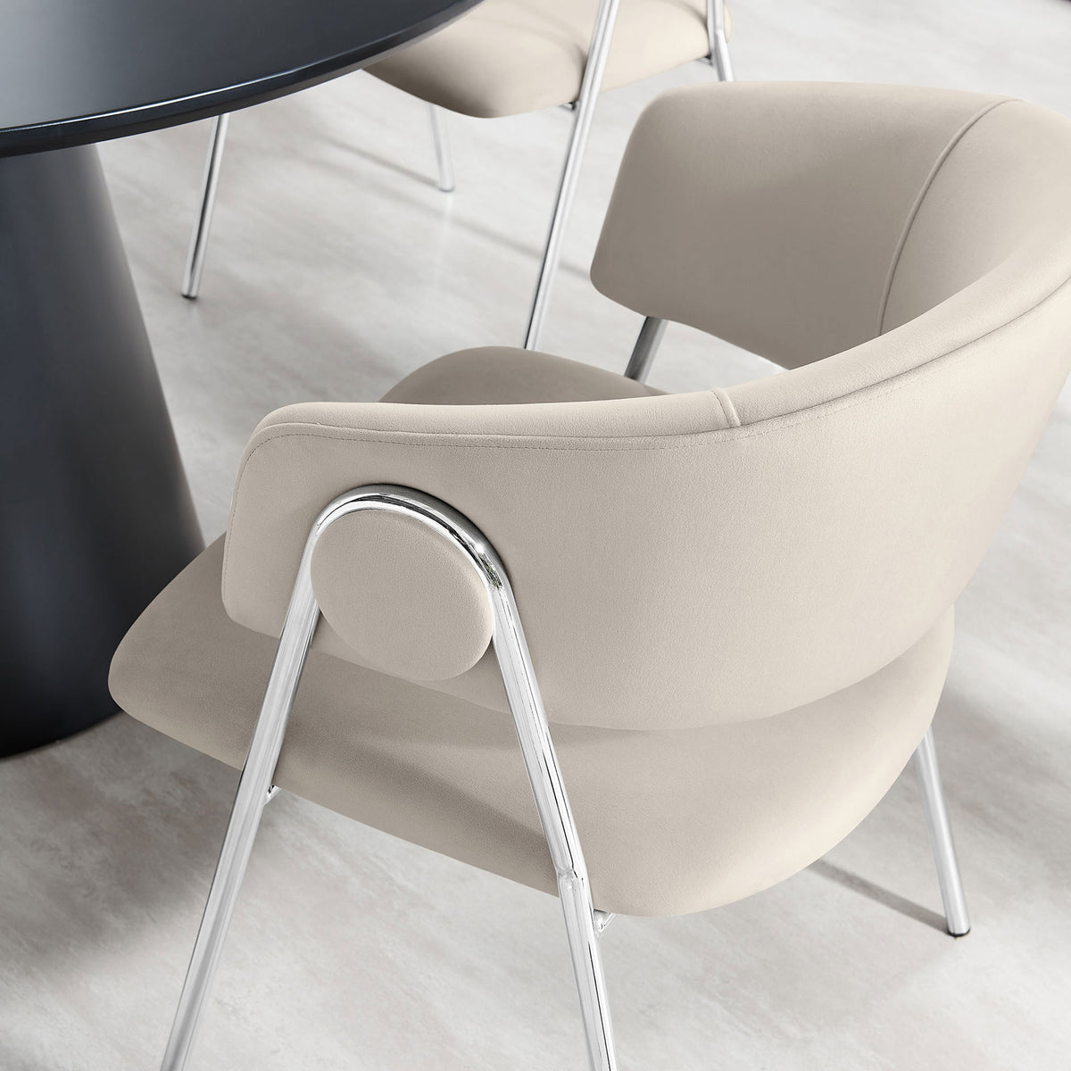 Almond silver velvet dining chair styled at a round table, adding soft curves and shine to the bright dining room. || EEI-7046-ALM-SLV || detail_room