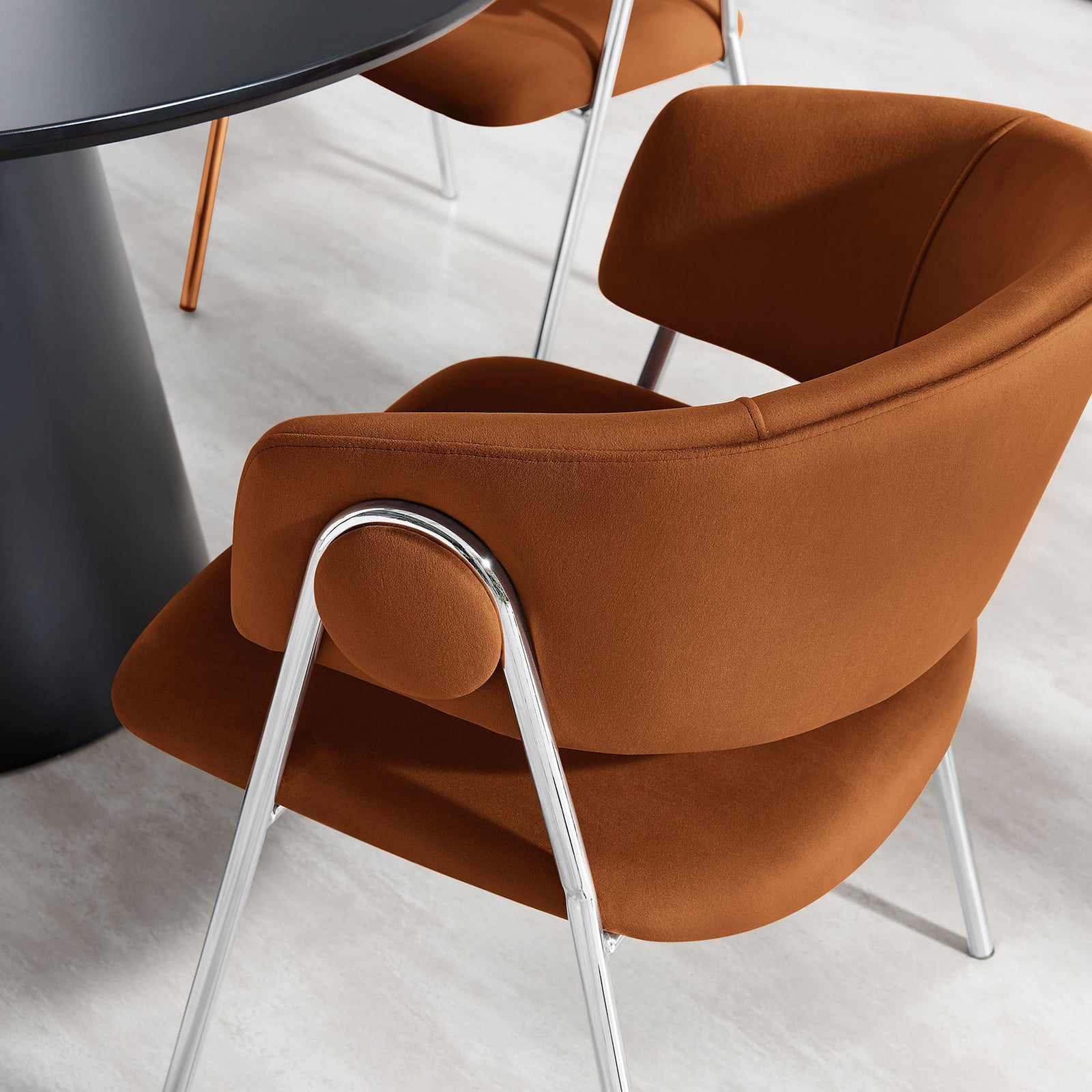 Rust velvet dining chair styled at a modern round table in a bright dining room || EEI-7046-RUS-SLV || detail_room