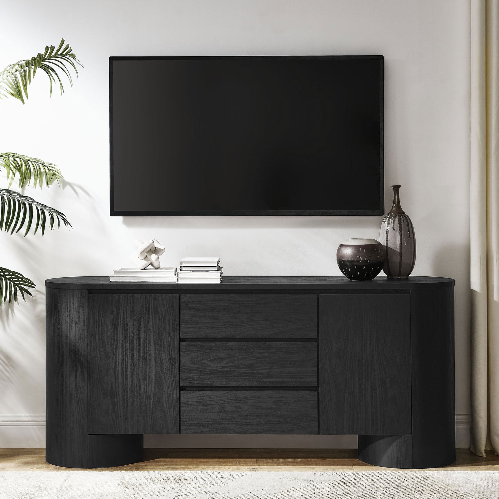 Black sideboard styled as a sleek media console beneath a wall-mounted TV in a bright modern living room || EEI-7050-BLK || front_angle_room