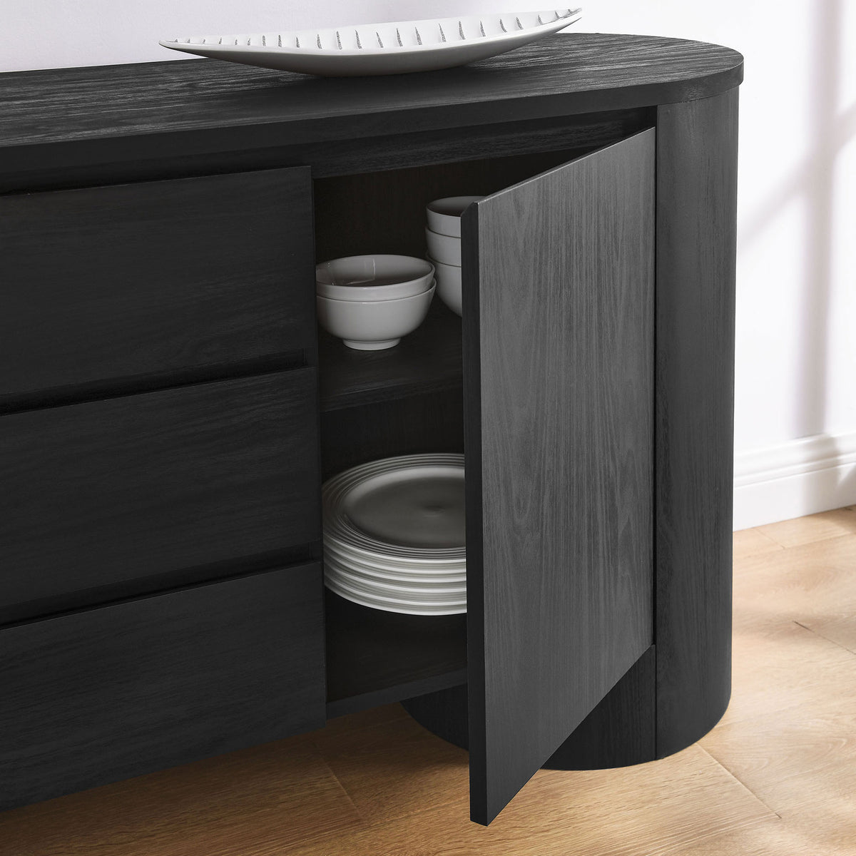 Sideboard cabinet door opens to reveal neatly organized dinnerware on adjustable shelves in a cozy dining nook || EEI-7050-BLK || storage_open_room