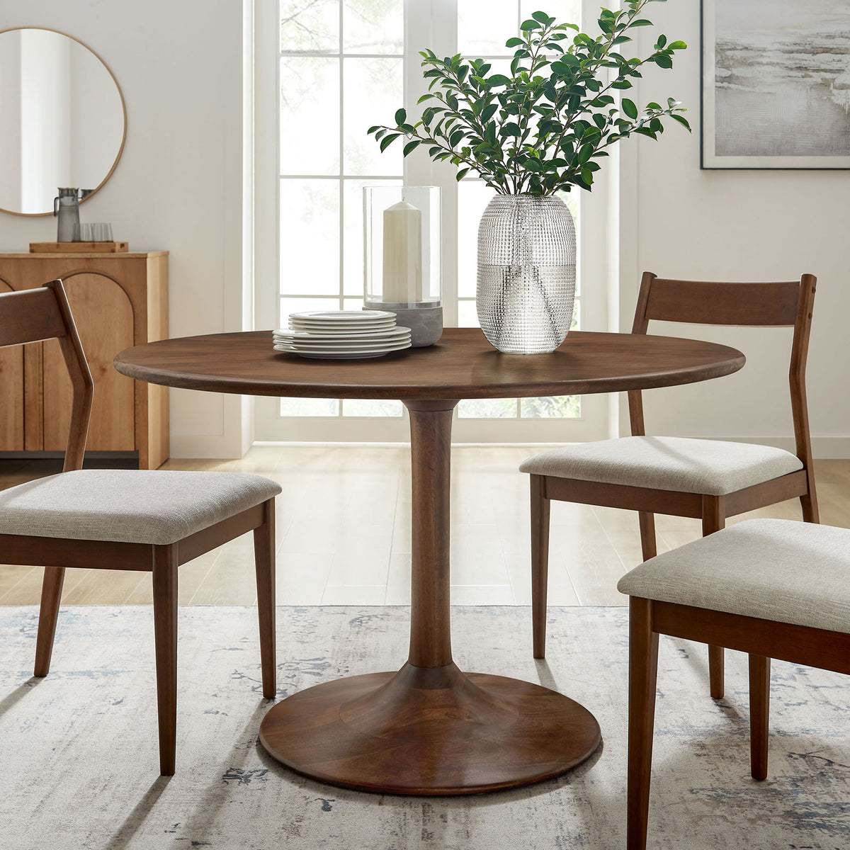 Walnut pedestal dining table anchors a bright dining room with coordinating chairs and fresh greenery. || EEI-7051-WAL || front_angle_room