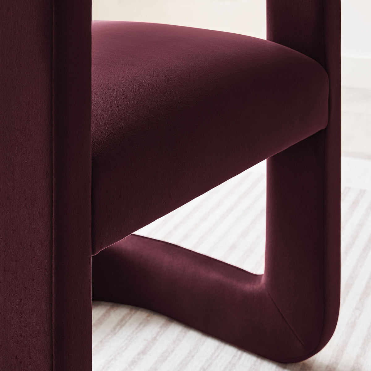 The mulberry velvet seat and sculptural base bring tactile softness to a light, modern dining room. || EEI-7052-MUL || detail_room