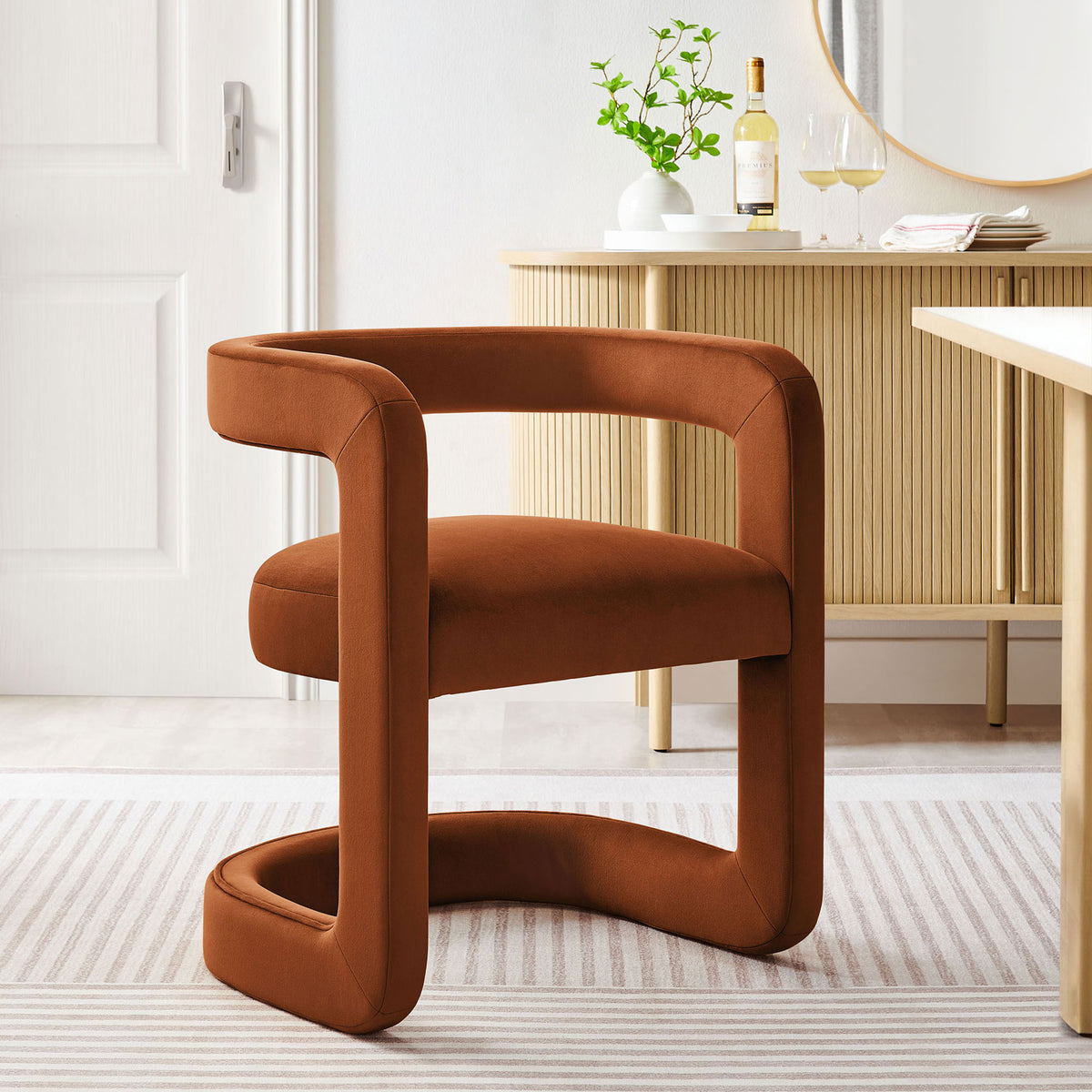 Rust velvet barrel dining chair styled in a bright dining room for a chic, contemporary statement || EEI-7052-RUS || front_angle_room