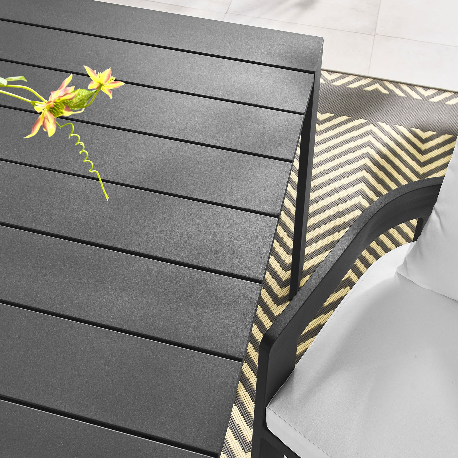 Slatted gray tabletop paired with outdoor seating and patterned rug for a chic patio look. || EEI-7054-GRY || detail_room