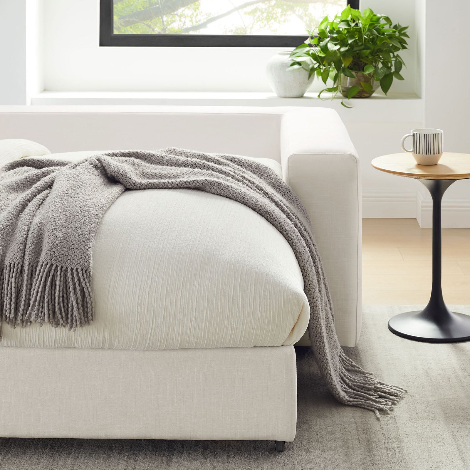 Textured throw blanket draped over the extended sleeper base beside a modern pedestal side table || EEI-7080-PUW || detail_room