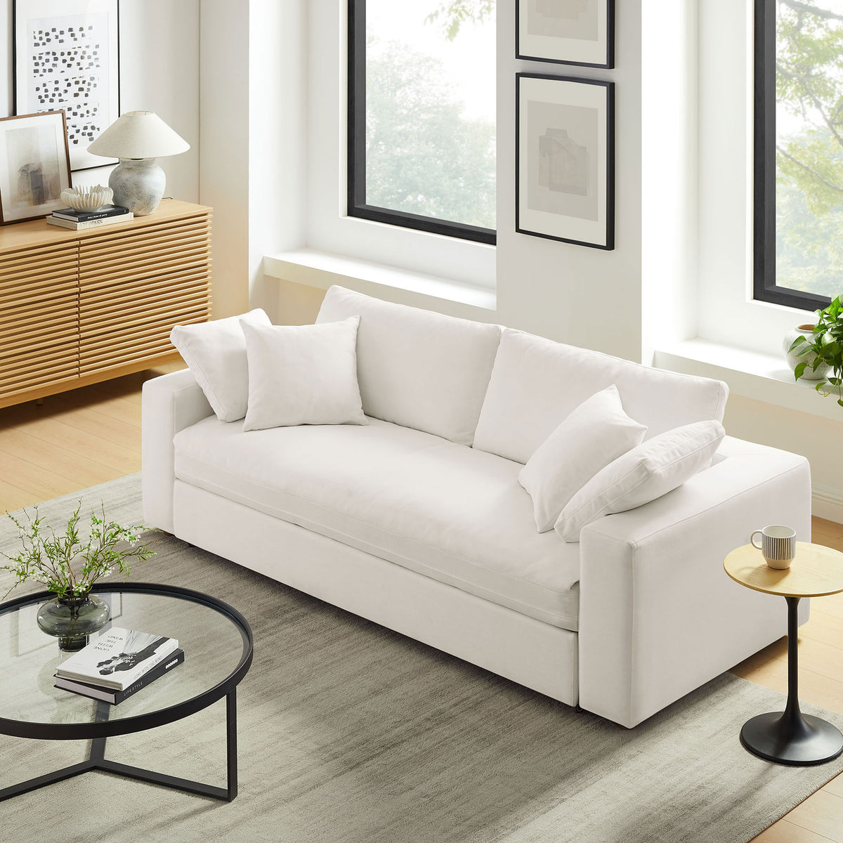 Pure white sleeper sofa styled in a bright living room with modern decor and soft area rug || EEI-7080-PUW || front_angle_room