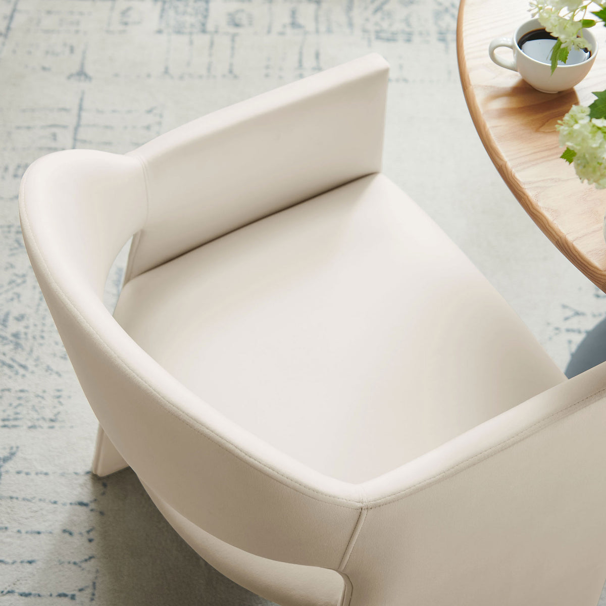Talia alabaster dining armchair at a round wood table, highlighting the smooth seat and slim arm silhouette || EEI-7081-ALA || detail_room