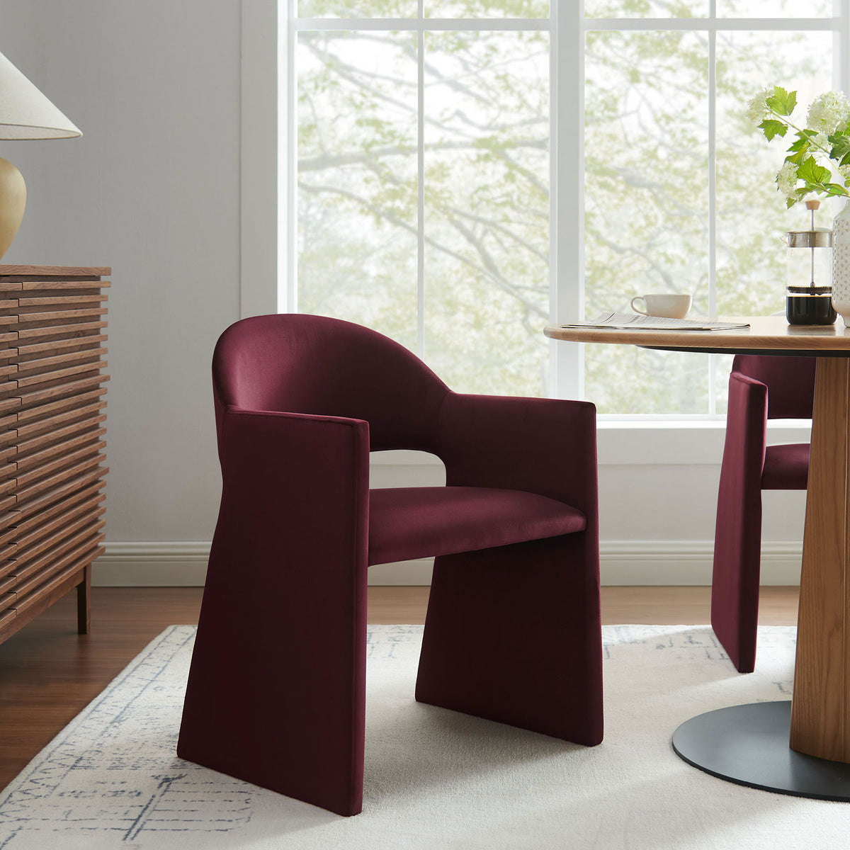 Mulberry velvet barrel-back dining armchair styled in a bright modern dining room with wood table || EEI-7081-MUL || front_angle_room