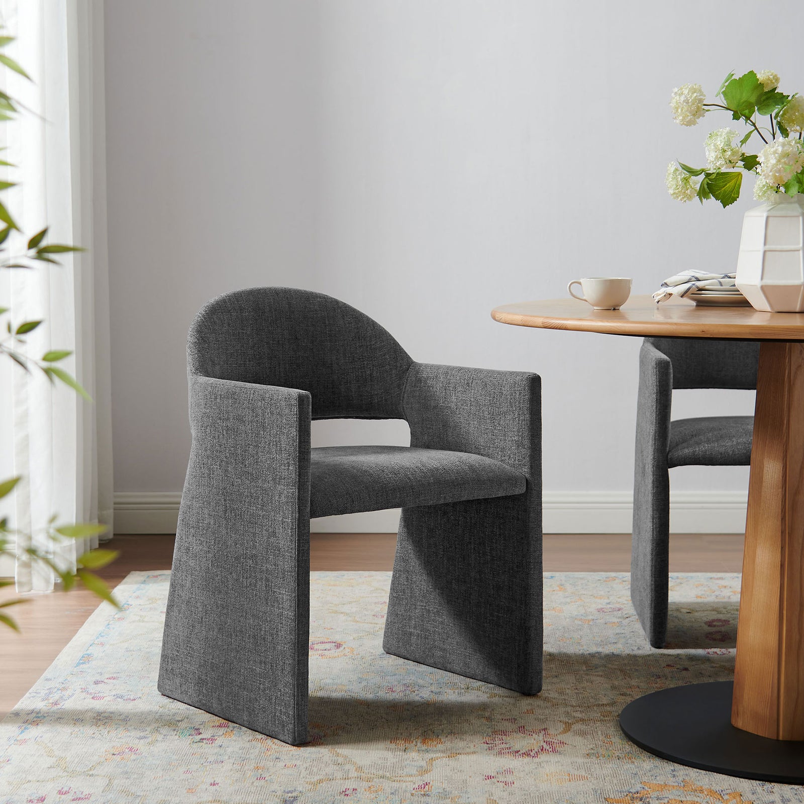 Talia charcoal upholstered dining armchair adding sculptural comfort to a bright dining nook || EEI-7082-CHA || front_angle_room