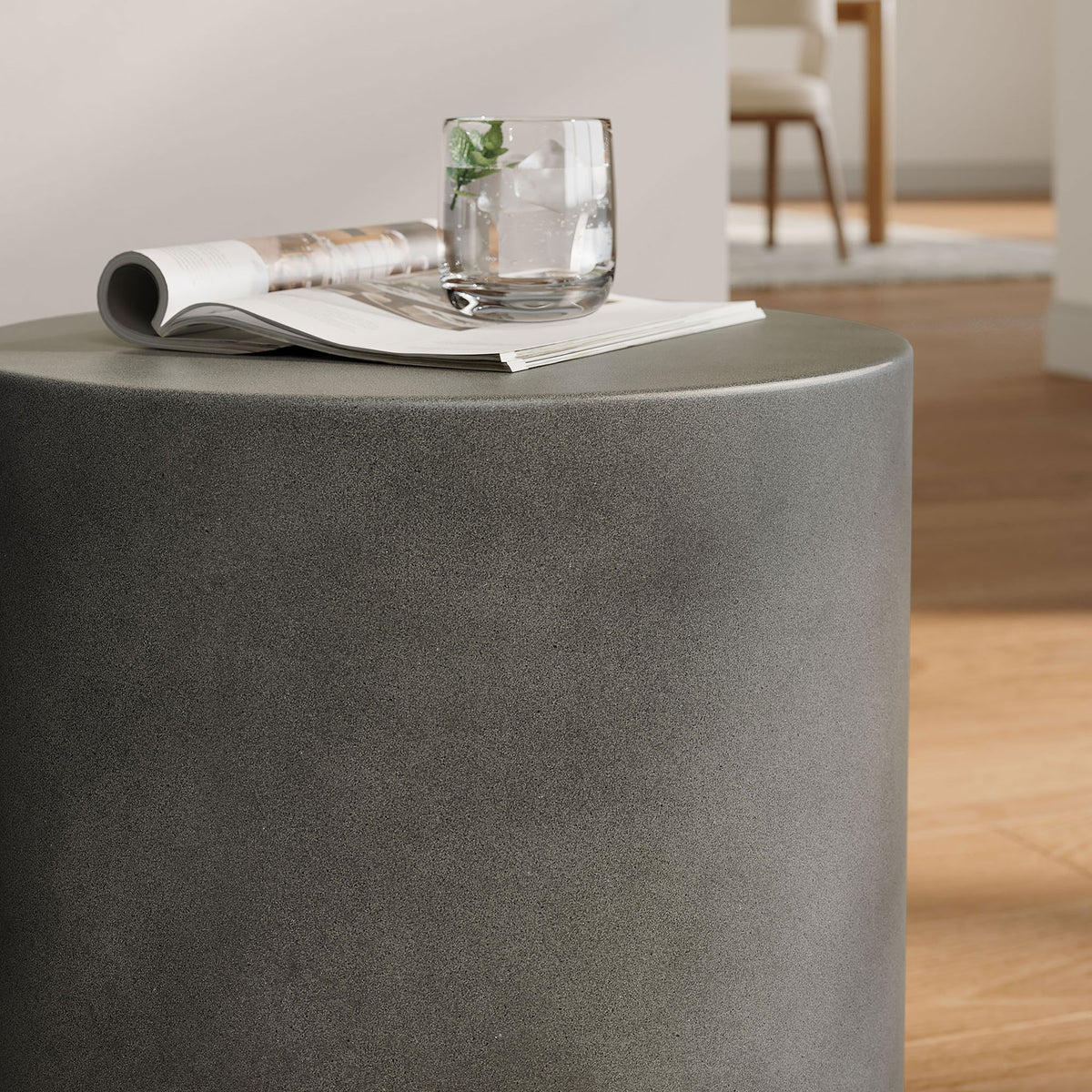 Gray concrete stool styled as a sleek living room side table with magazine and drink on top || EEI-7088-GRY || detail_room