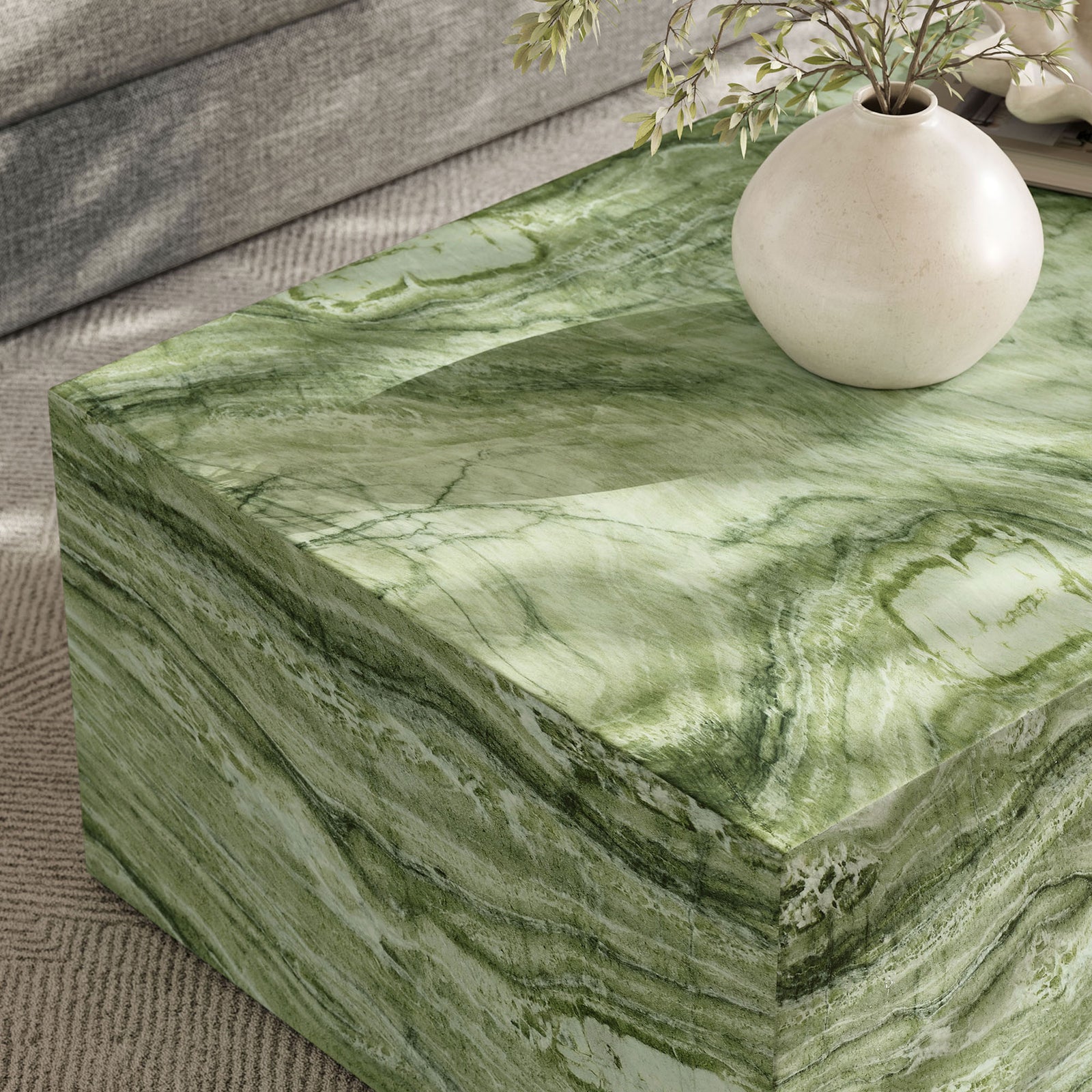 Green marble-effect coffee table corner styled with a rounded vase, highlighting the smooth faux stone texture || EEI-7095-GRN || detail_room