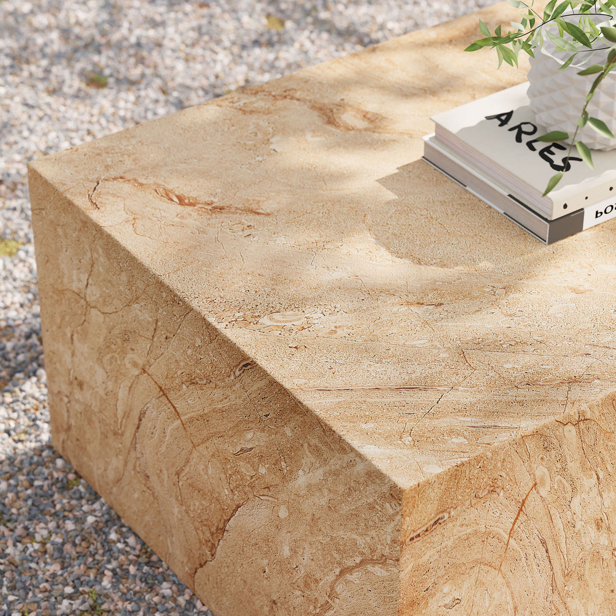 Outdoor view of the travertine-look coffee table styled with books and greenery, emphasizing its durable concrete build || EEI-7095-TRV || detail_room