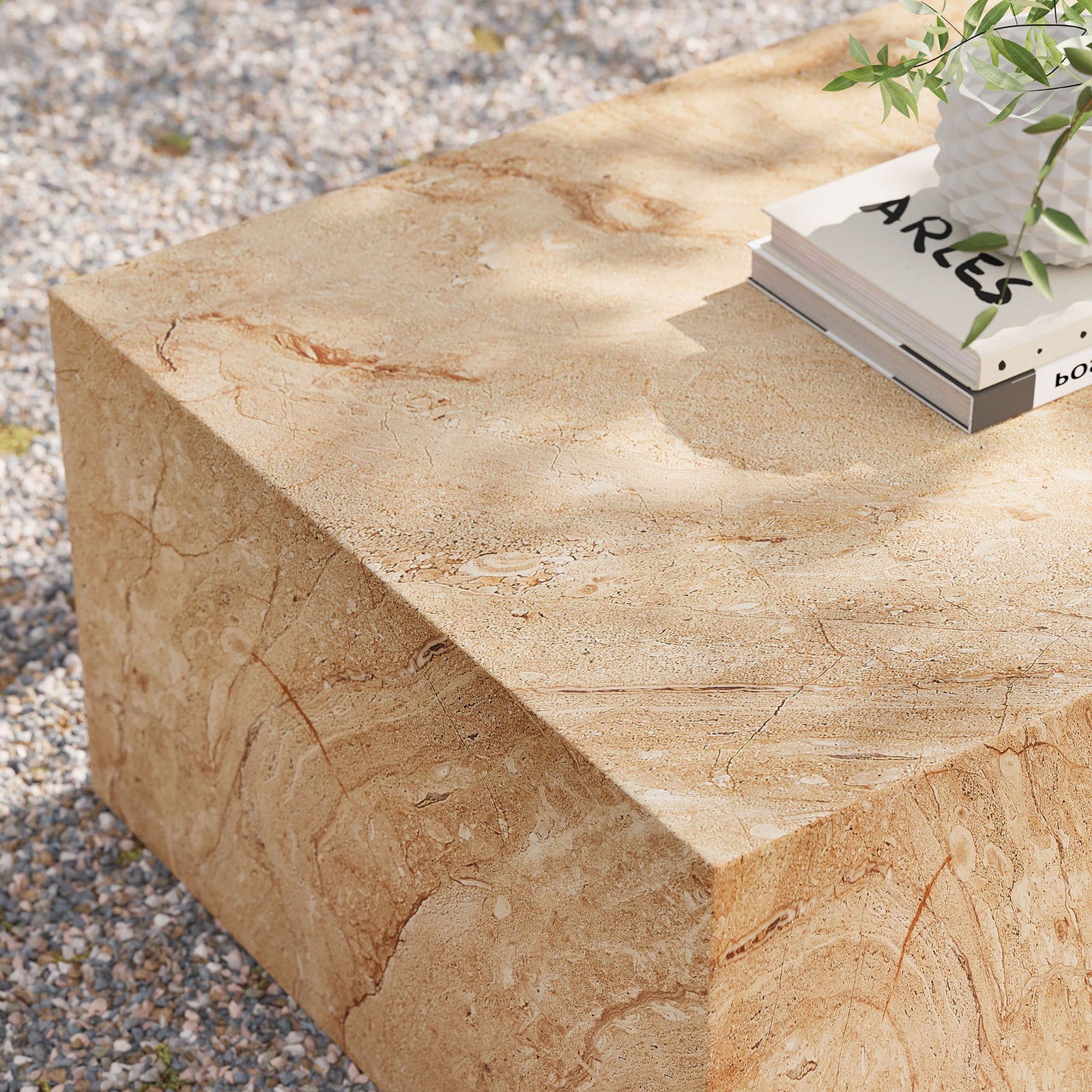Outdoor view of the travertine-look coffee table styled with books and greenery, emphasizing its durable concrete build || EEI-7095-TRV || detail_room