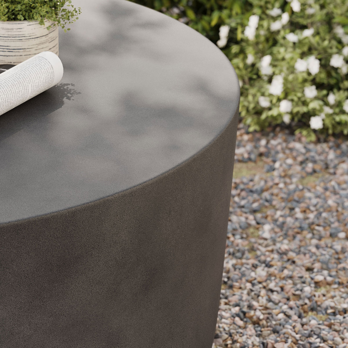 Gray concrete tabletop styled with a planter and magazine to showcase its weather-ready design || EEI-7099-GRY || detail_room
