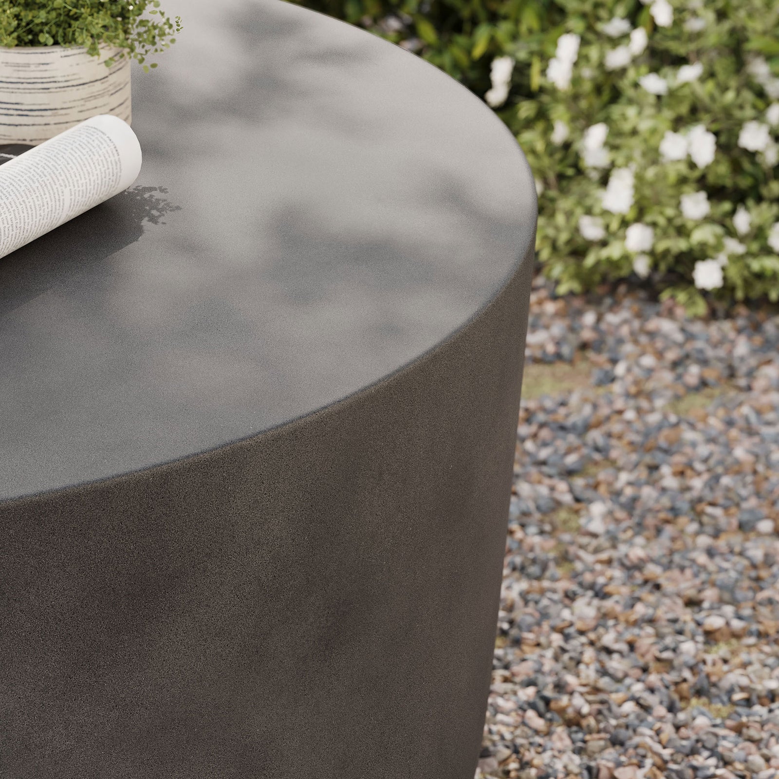 Gray concrete tabletop styled with a planter and magazine to showcase its weather-ready design || EEI-7099-GRY || detail_room
