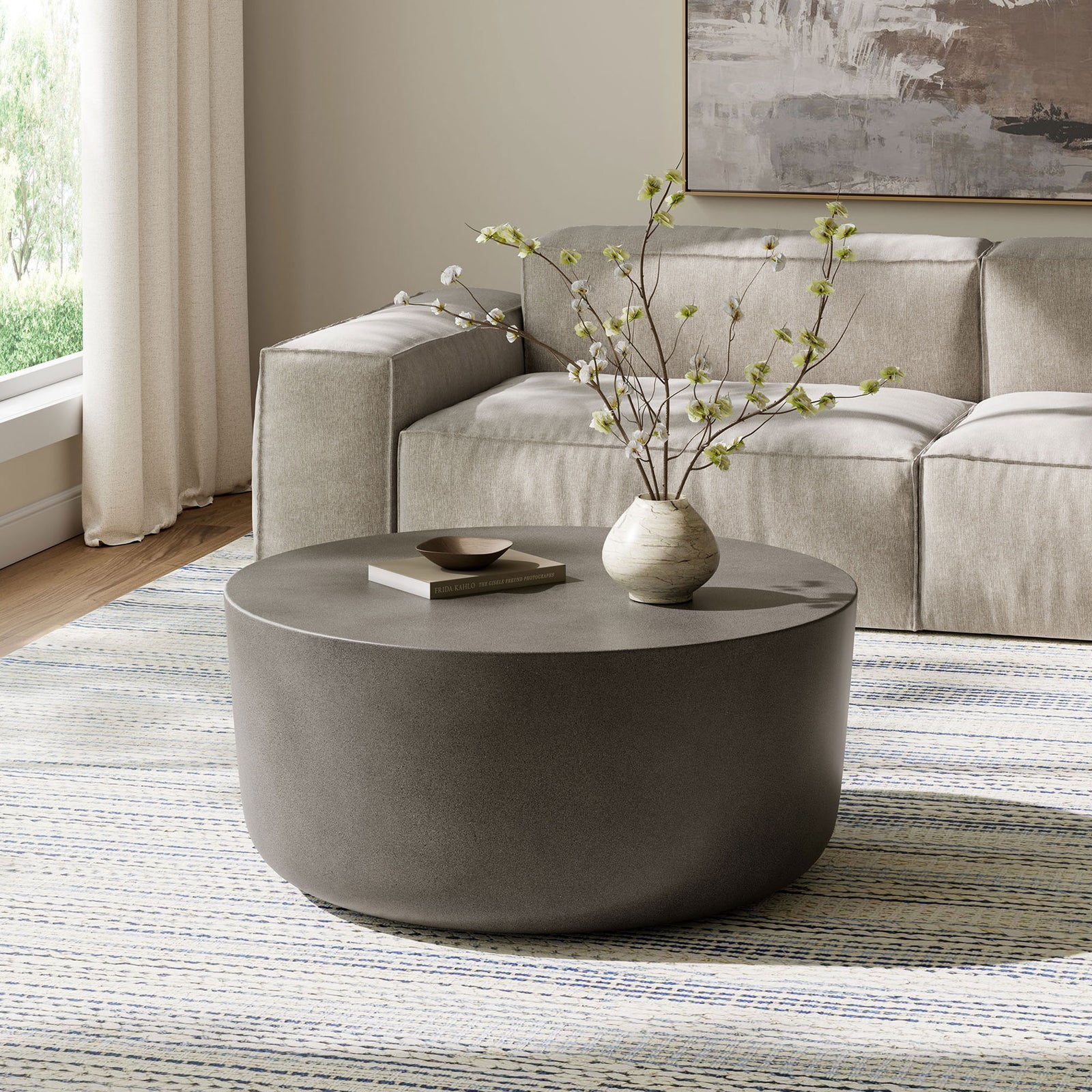 Gray concrete drum coffee table grounding a contemporary living room with clean, minimalist style || EEI-7099-GRY || front_angle_room