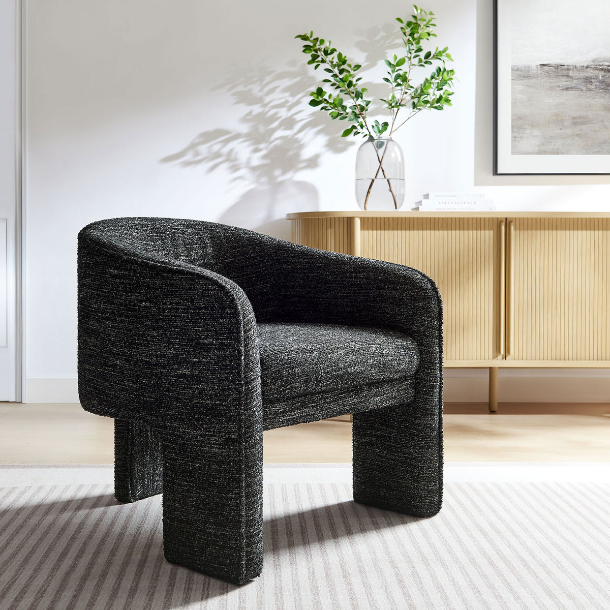 Statement barrel chair elevates spaces with its charcoal boucle and bold three-legged form || EEI-7101-CHA || front_angle_room
