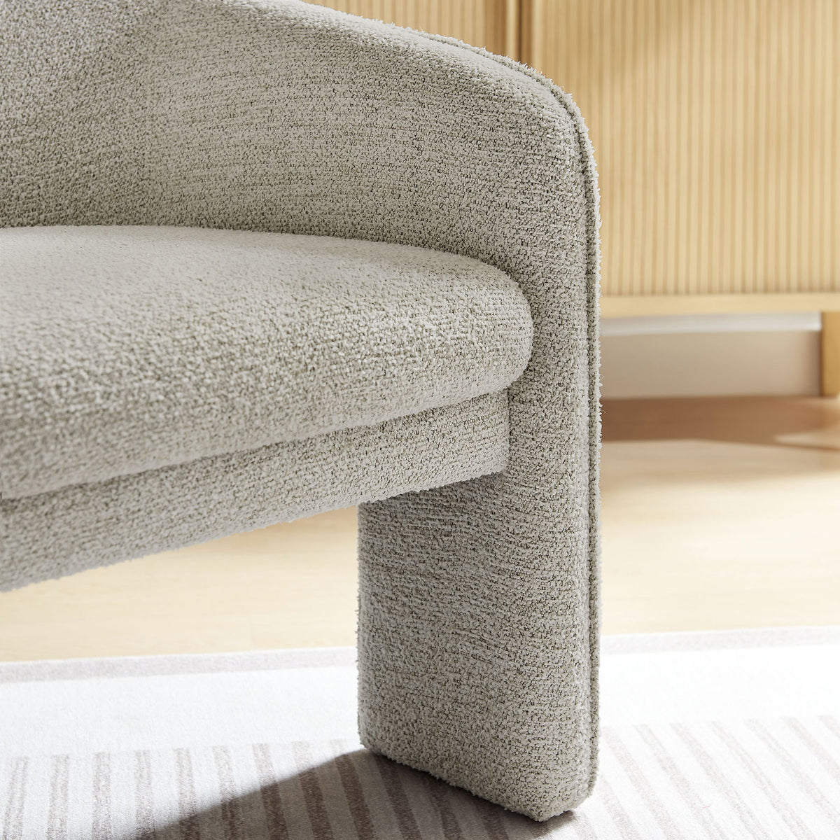 Textured boucle and tailored edges add inviting comfort to the sculpted arm and seat || EEI-7101-PCH || detail_room