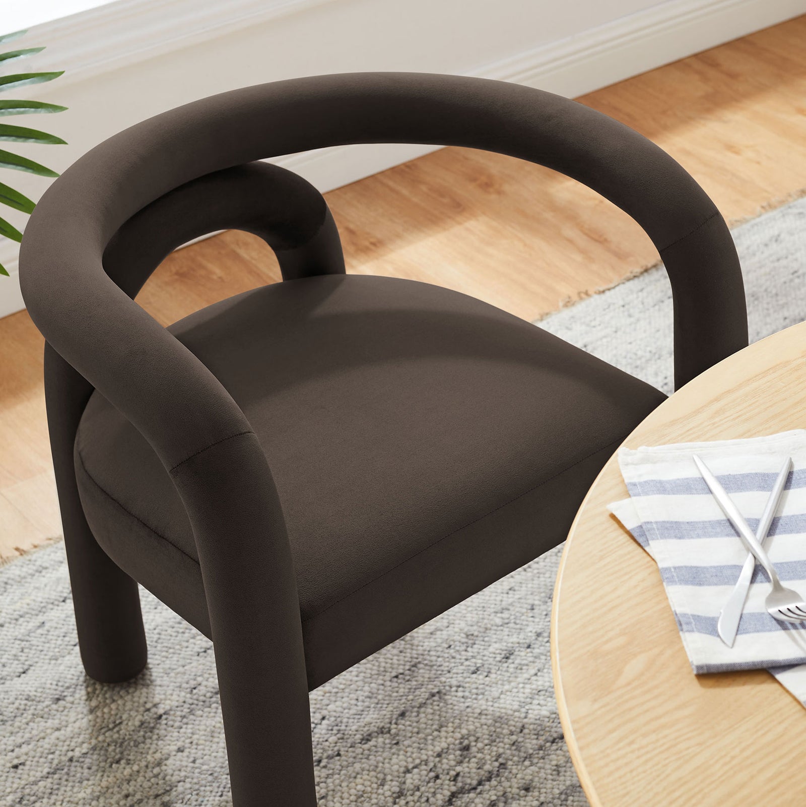 Cocoa velvet dining chair next to a light wood table in a bright contemporary dining space || EEI-7104-COA || detail_room