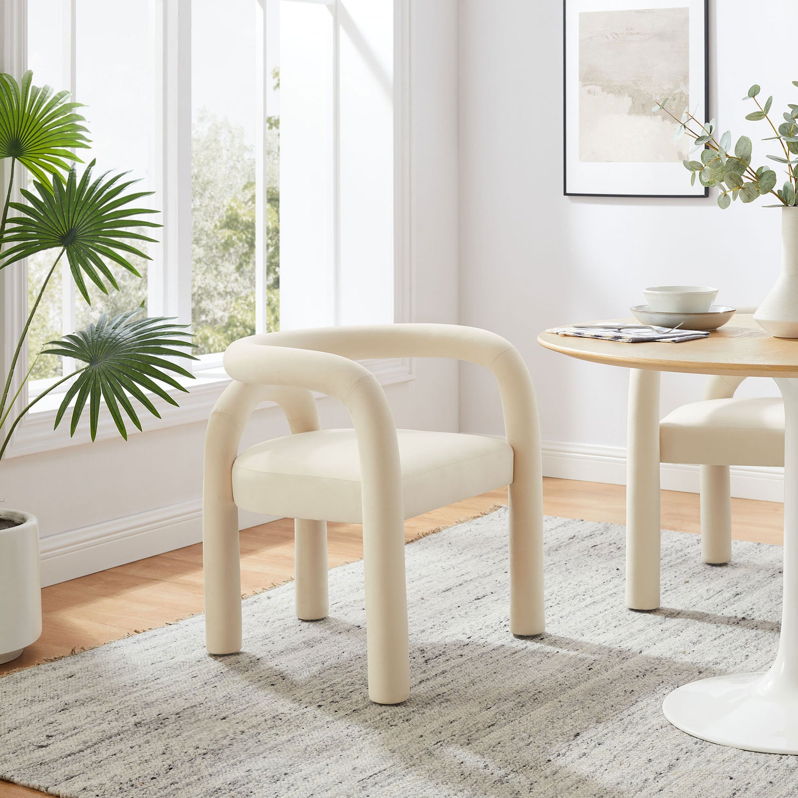 Porcelain performance velvet dining chair adding sculptural comfort to a sunlit contemporary dining space || EEI-7104-POR || front_angle_room