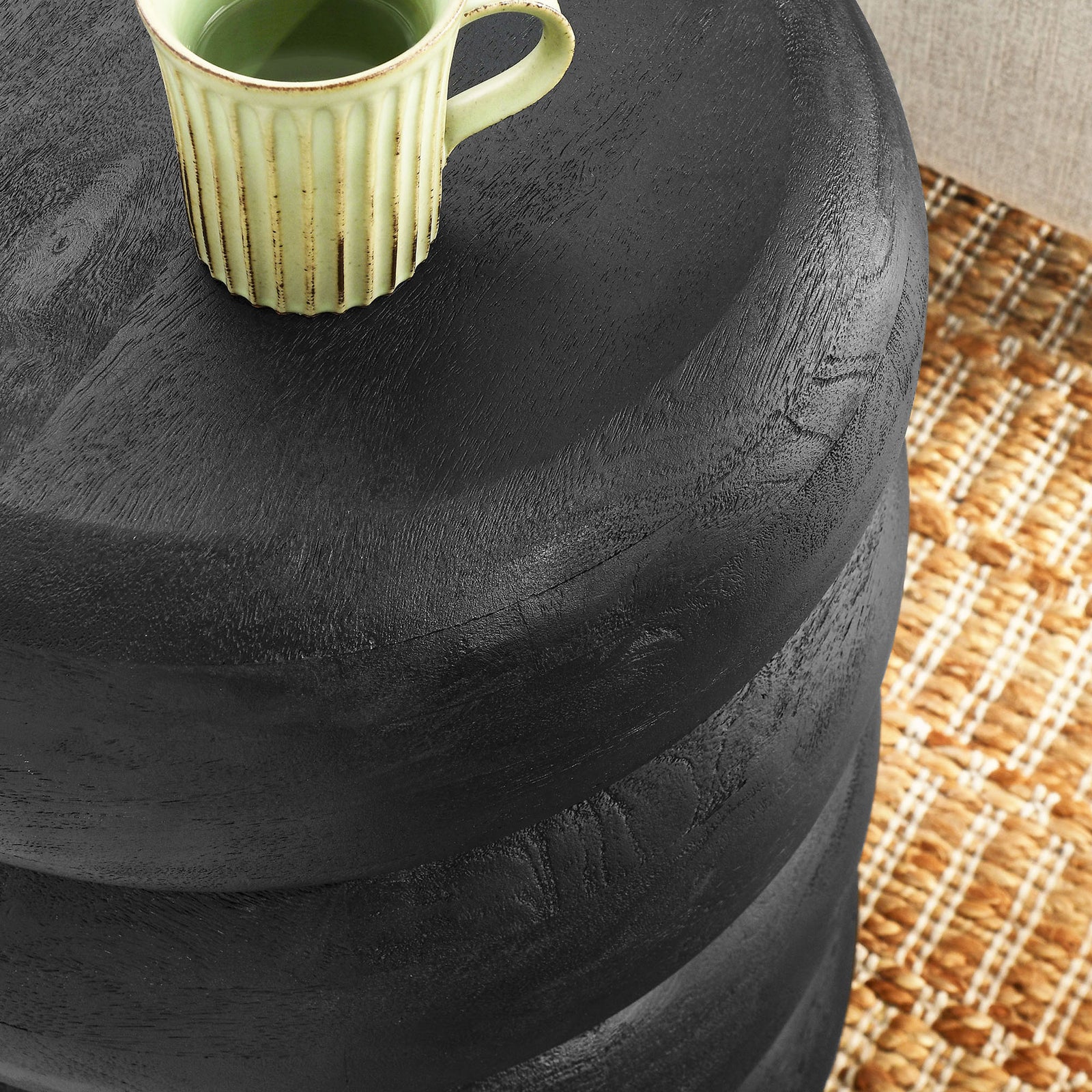 Black stacked wood side table top styled with mug on woven rug || EEI-7106-BLK || detail_room