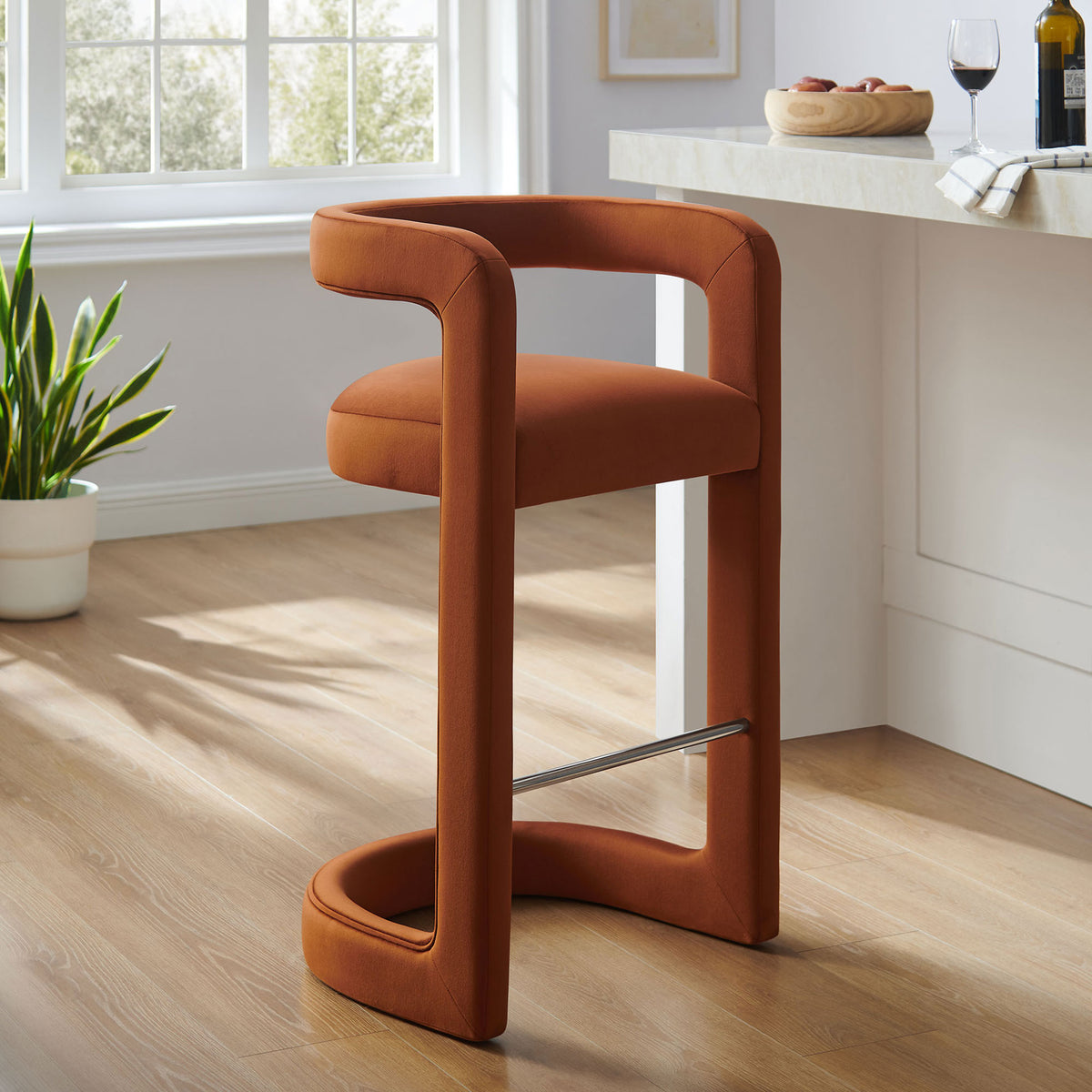 Modern bar stool in rich rust velvet, pairing sculptural lines with a polished footrest || EEI-7108-RUS || front_angle_room