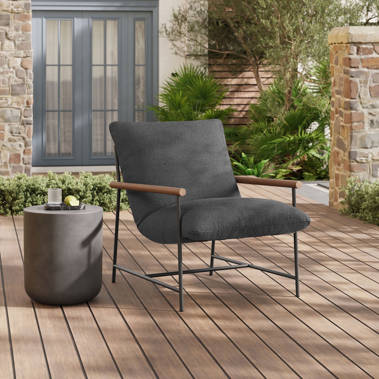 Charcoal boucle sling lounge chair styled on a contemporary deck beside a round concrete side table || EEI-7118-CHA || front_angle_room