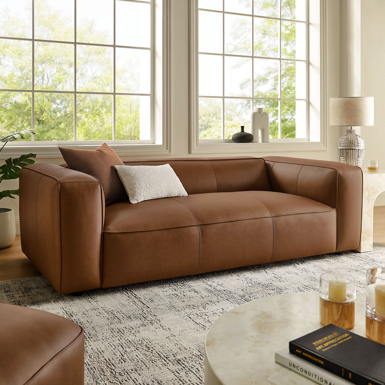 Coffee vegan leather sofa anchored in a cozy living room with pillows and textured rug || EEI-7119-COF || front_angle_room