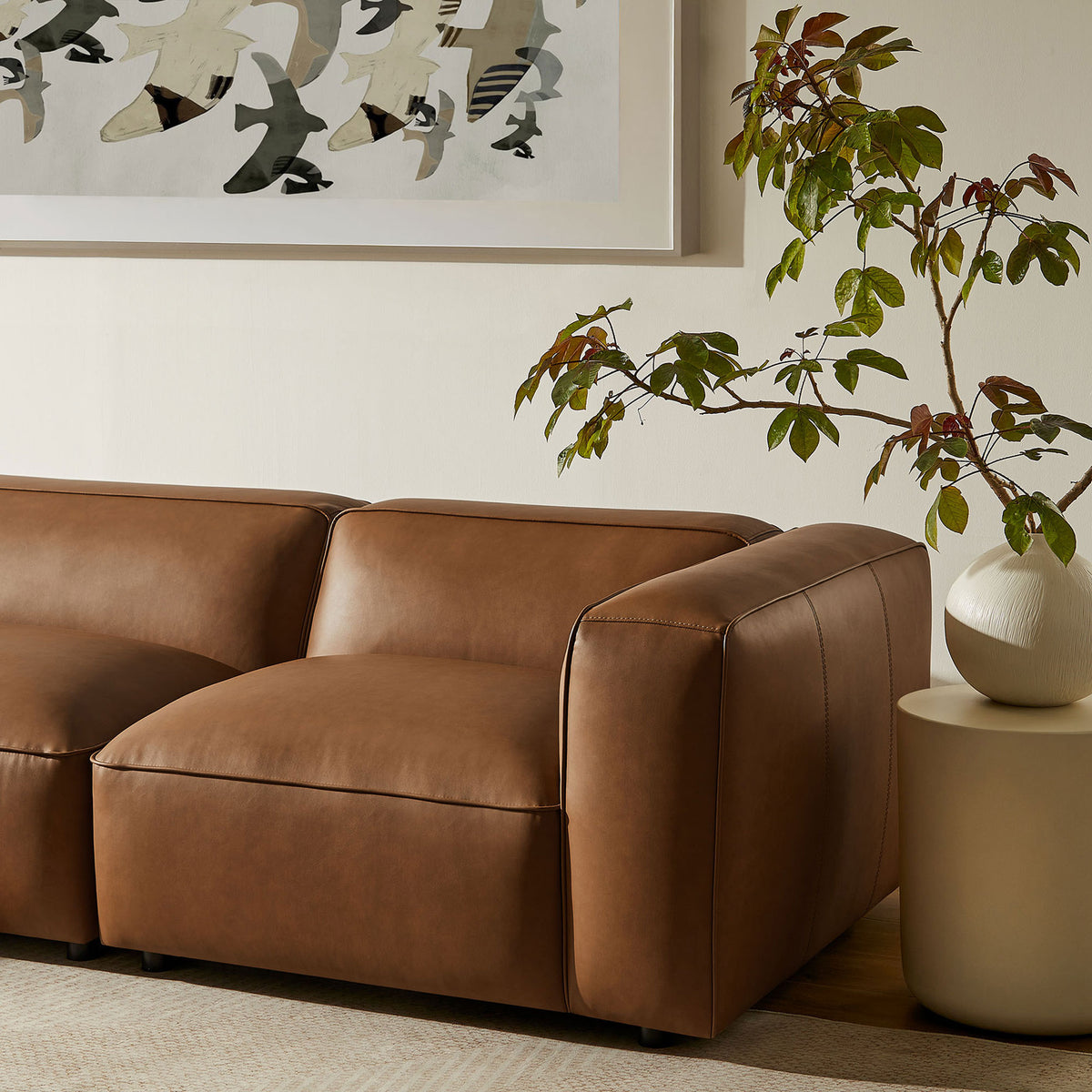Low profile coffee vegan leather corner sofa section styled with round side table and leafy plant || EEI-7128-COF || front_angle_partial_room