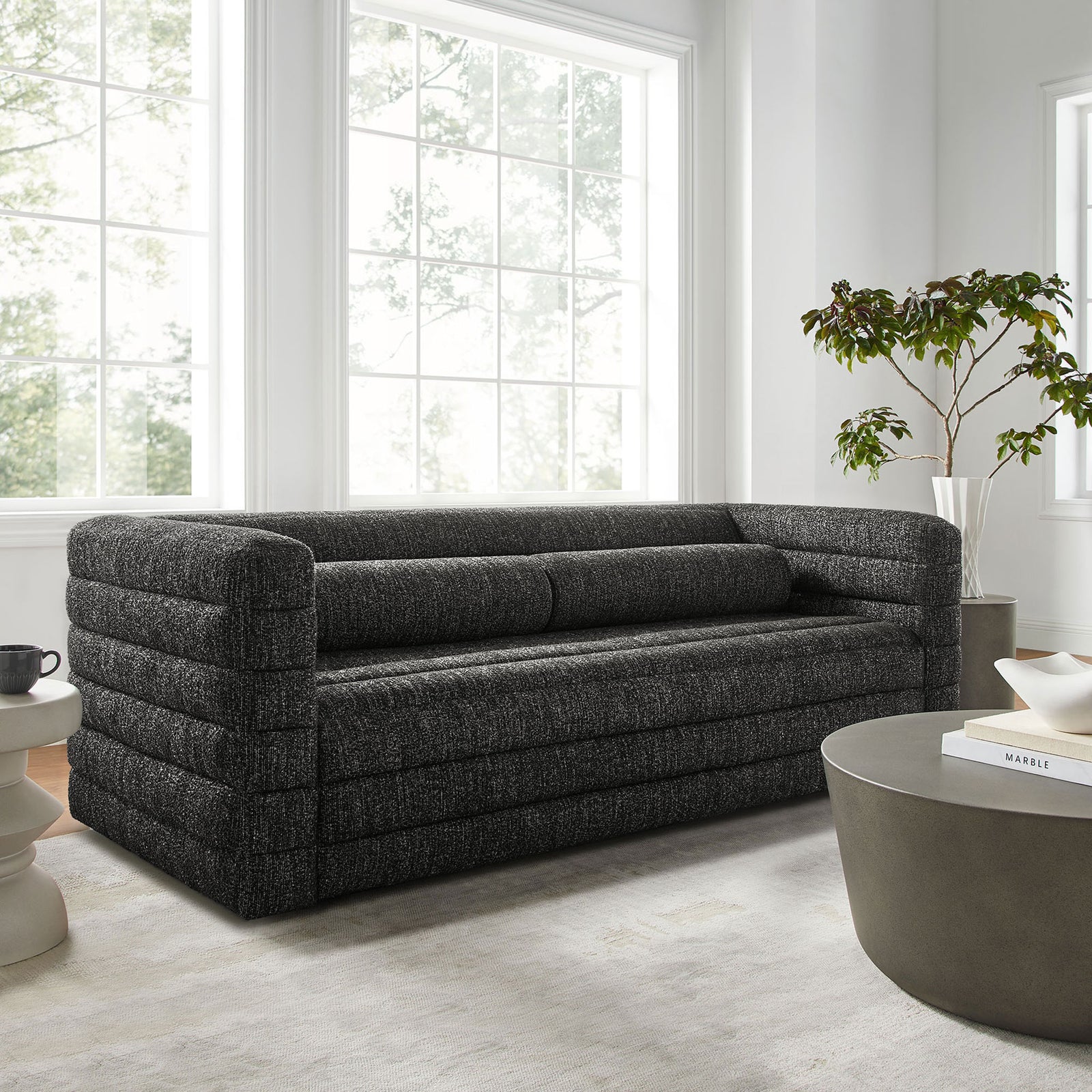 Charcoal boucle Relle sofa anchors a bright living room with layered channel tufting and plush bolster pillows || EEI-7136-CHA || front_angle_room